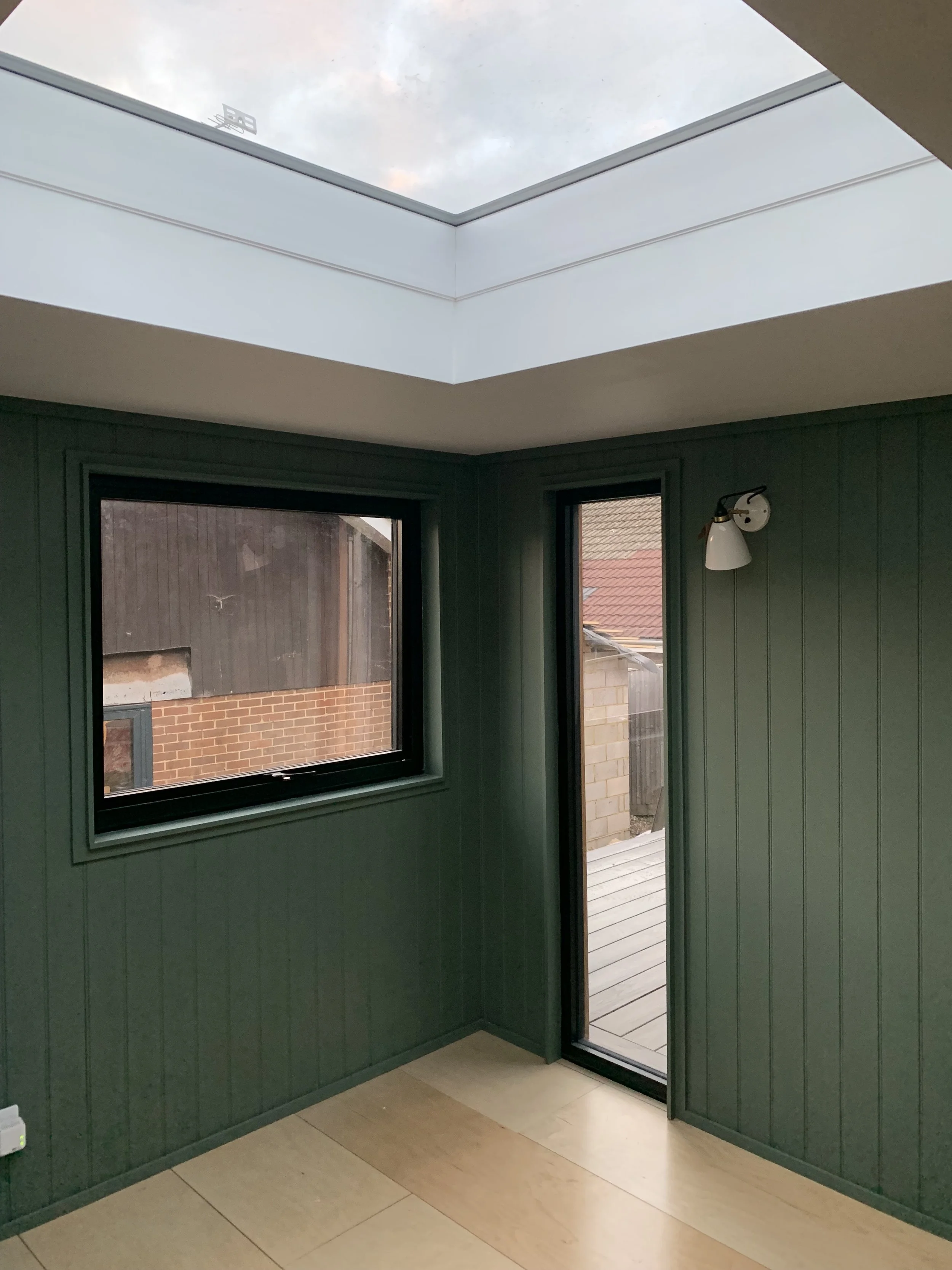 wood panelled walls with skylight and birch ply floors