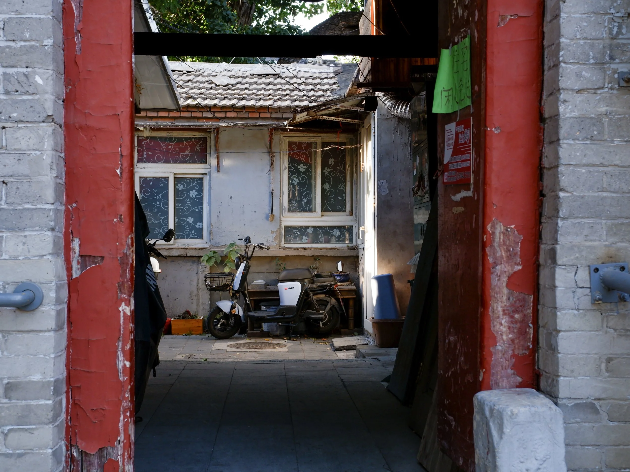 A scooter in a hutong courtyard.
