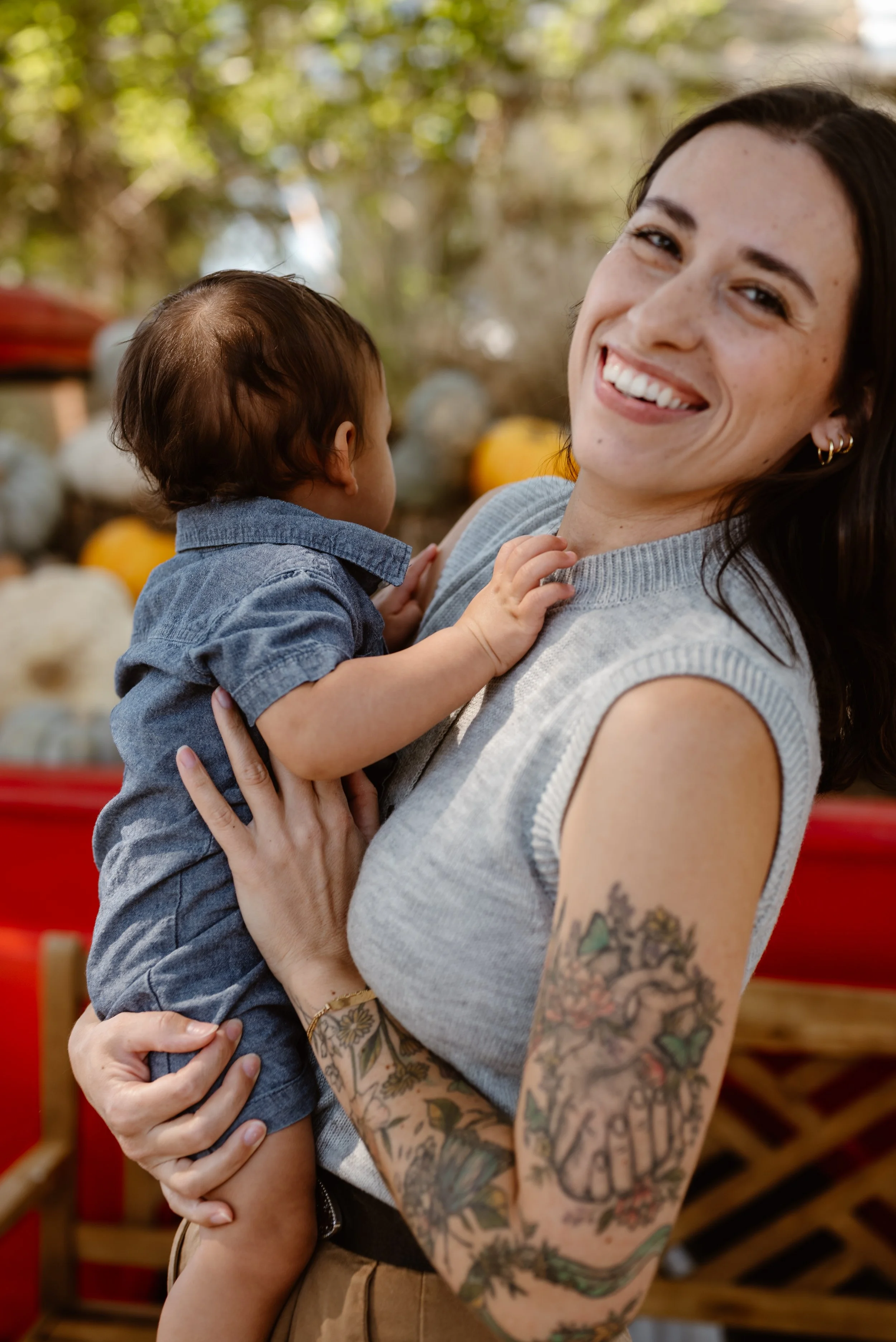 A mom smiles while holding her baby during a mommy and me photoshoot