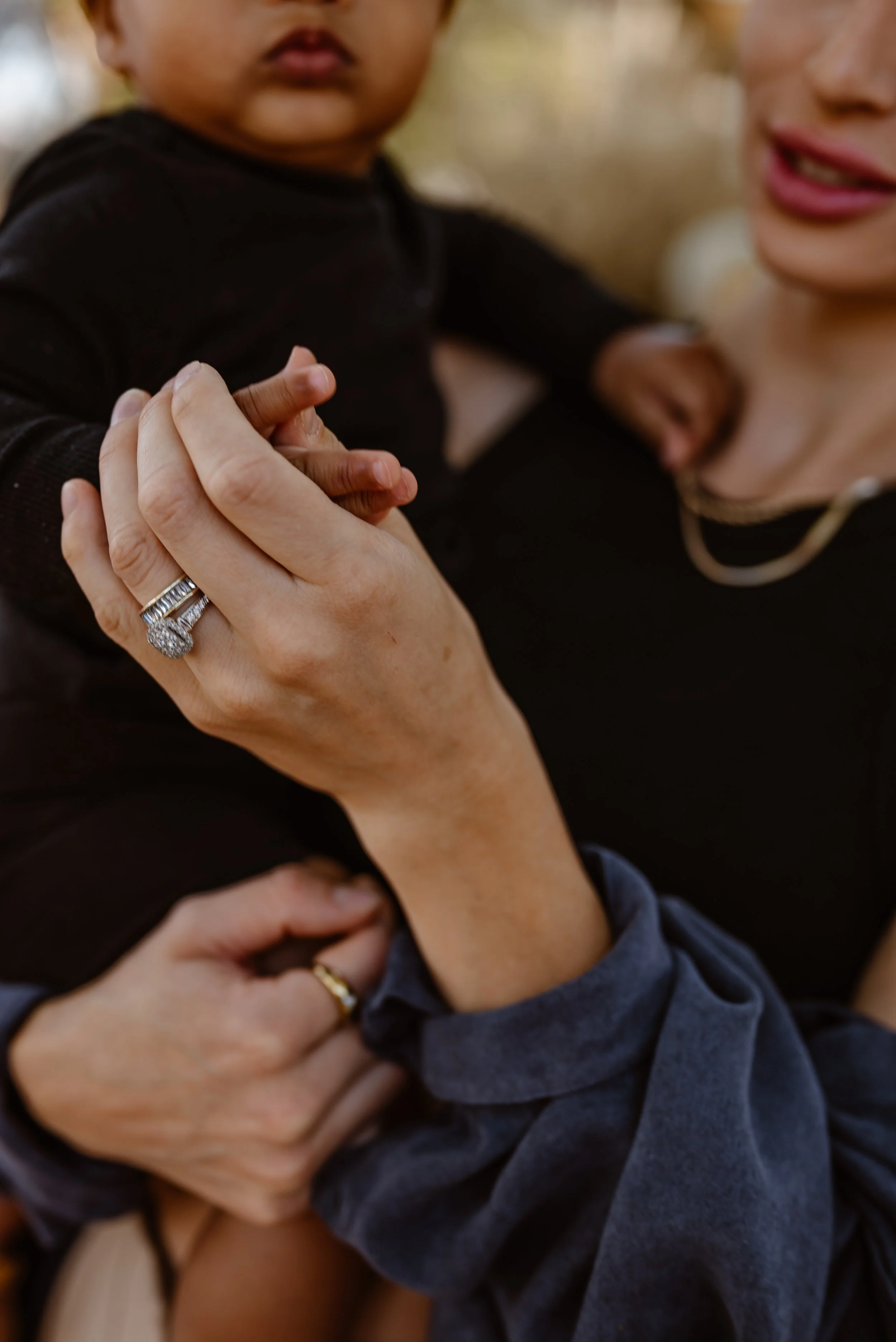 A mom holds her baby's hand