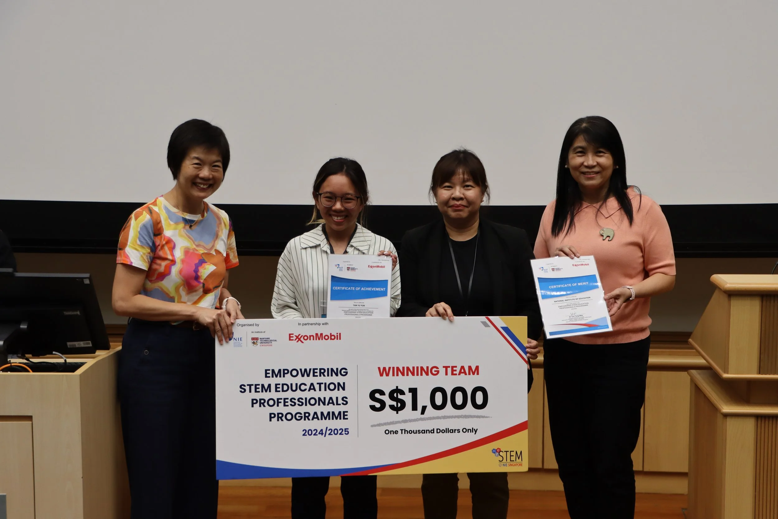 Winning team from the National Institute of Education receiving their winning cheque from A/P Teo, A/P Tan and Ms. Karen Wong.