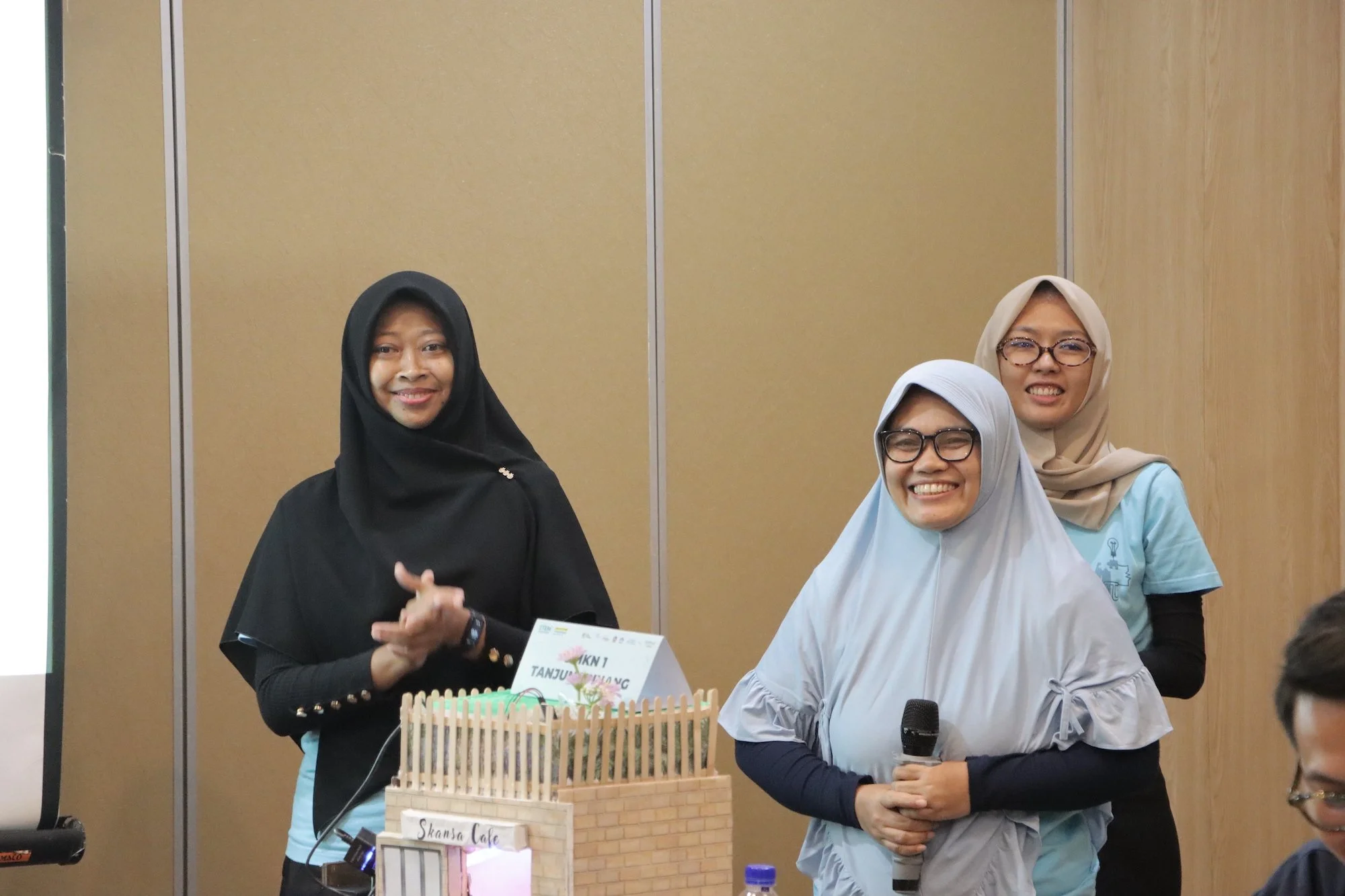  SMKN 1 Tanjungpinang presenting their smart café prototype featuring automated technologies with Micro:bit and Grove Inventor kits for a futuristic dining experience 