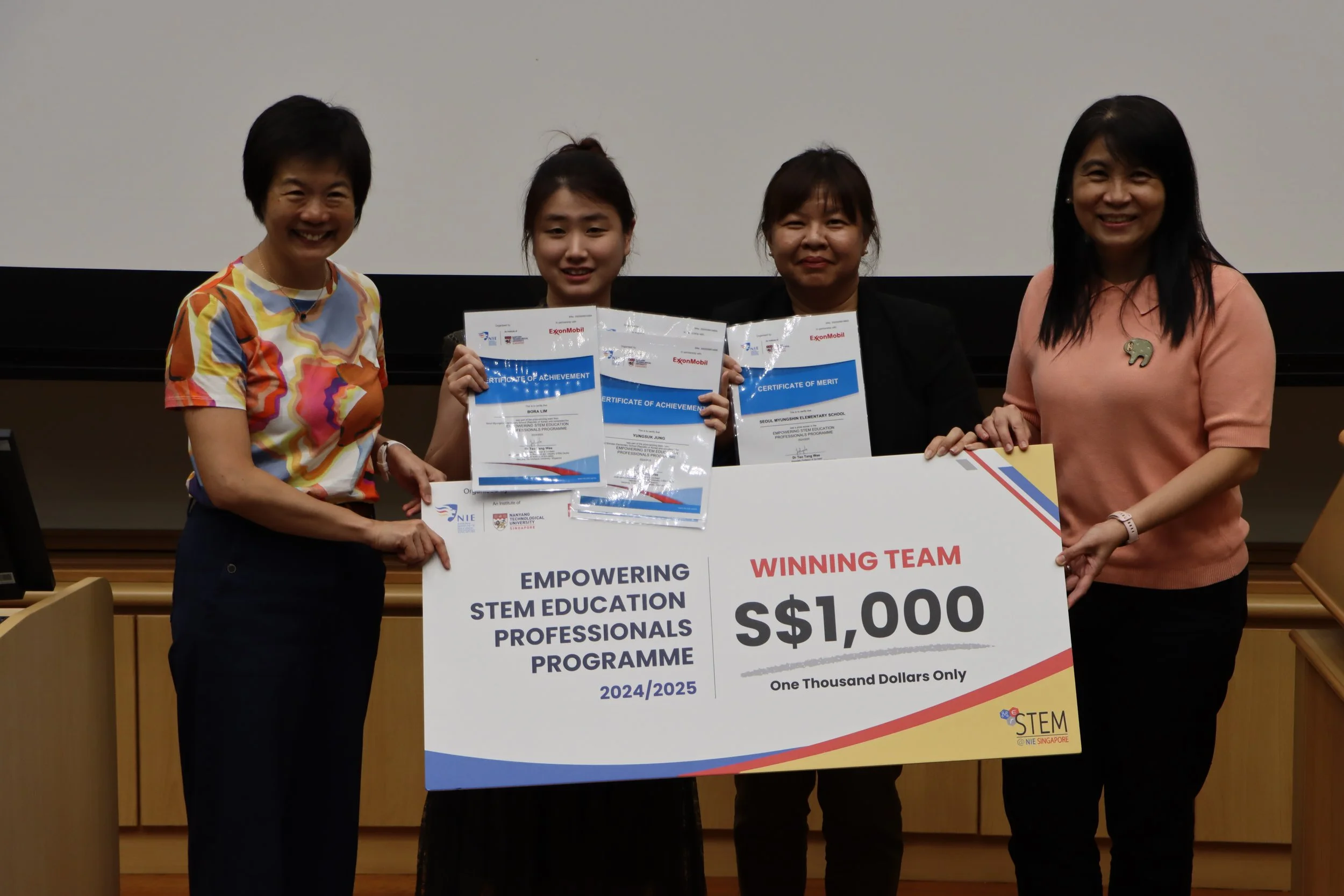 Winning team from Seoul Myungshin Elementary School, as part of the combined elementary schools from Seoul, receiving their winning cheque from A/P Teo, A/P Tan and Ms. Karen Wong.
