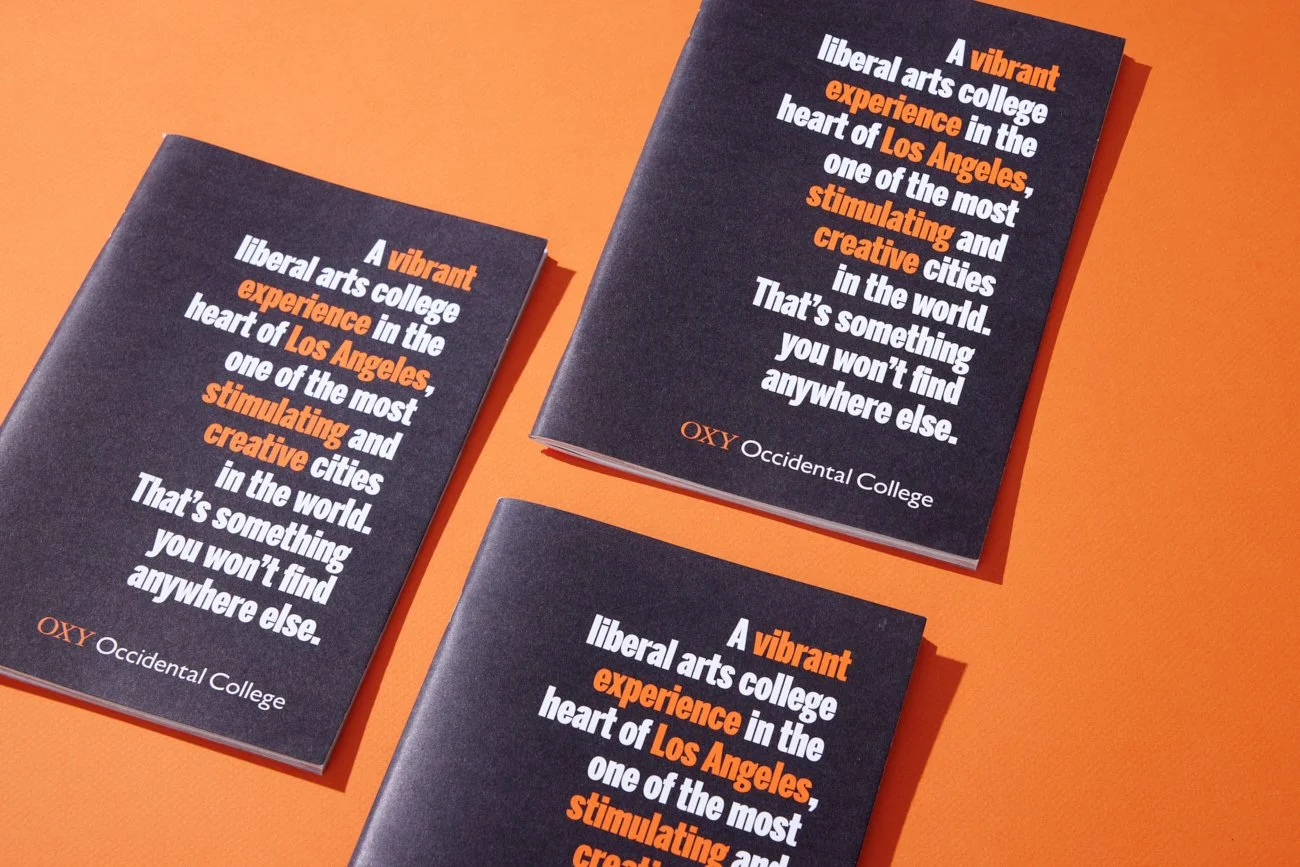 Three brochures with dark blue covers and white and orange text on an orange background. The text promotes Occidental College in Los Angeles.