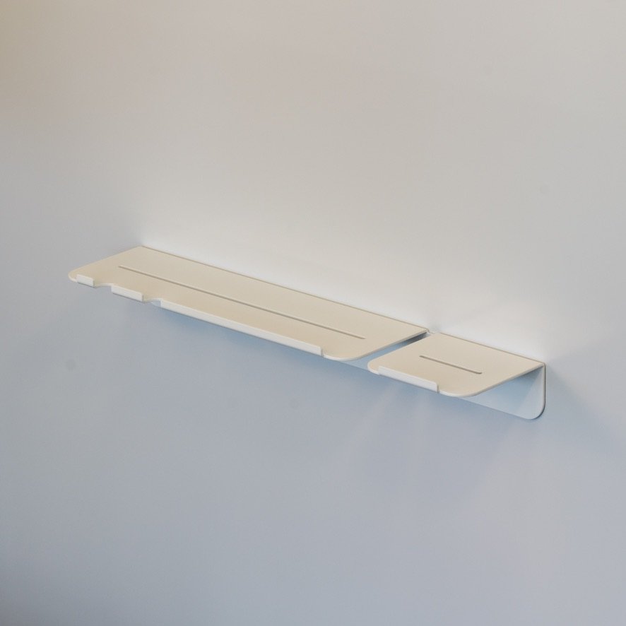 Minimalist white aluminum shower shelf photographed in a studio for a product shot.