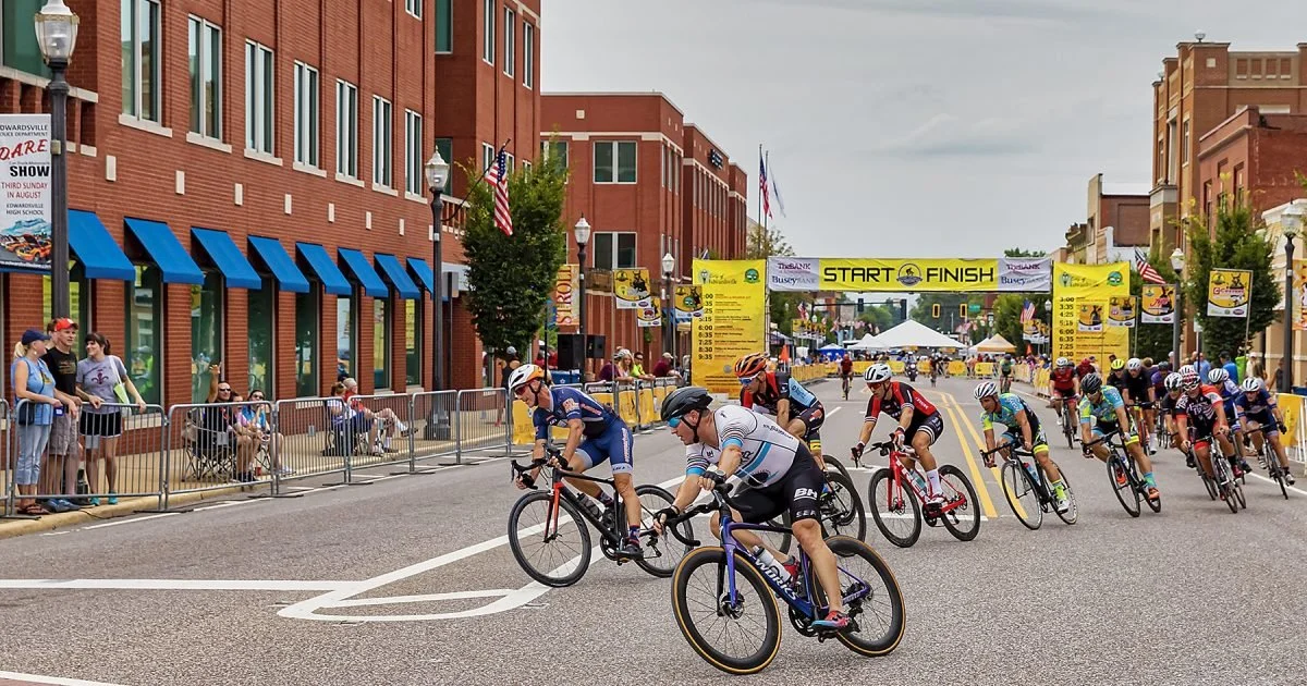 Bike race in the historic downtown Edwardsville. 6 bicyclist in the forground turning to the left with the starting line in the background.