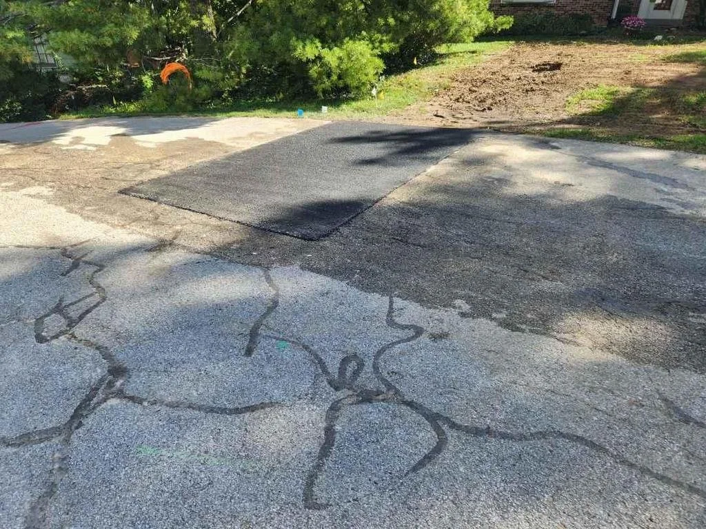 Saint Ann street from earlier photo except the asphalt is now patched and matches the existing asphalt around it.