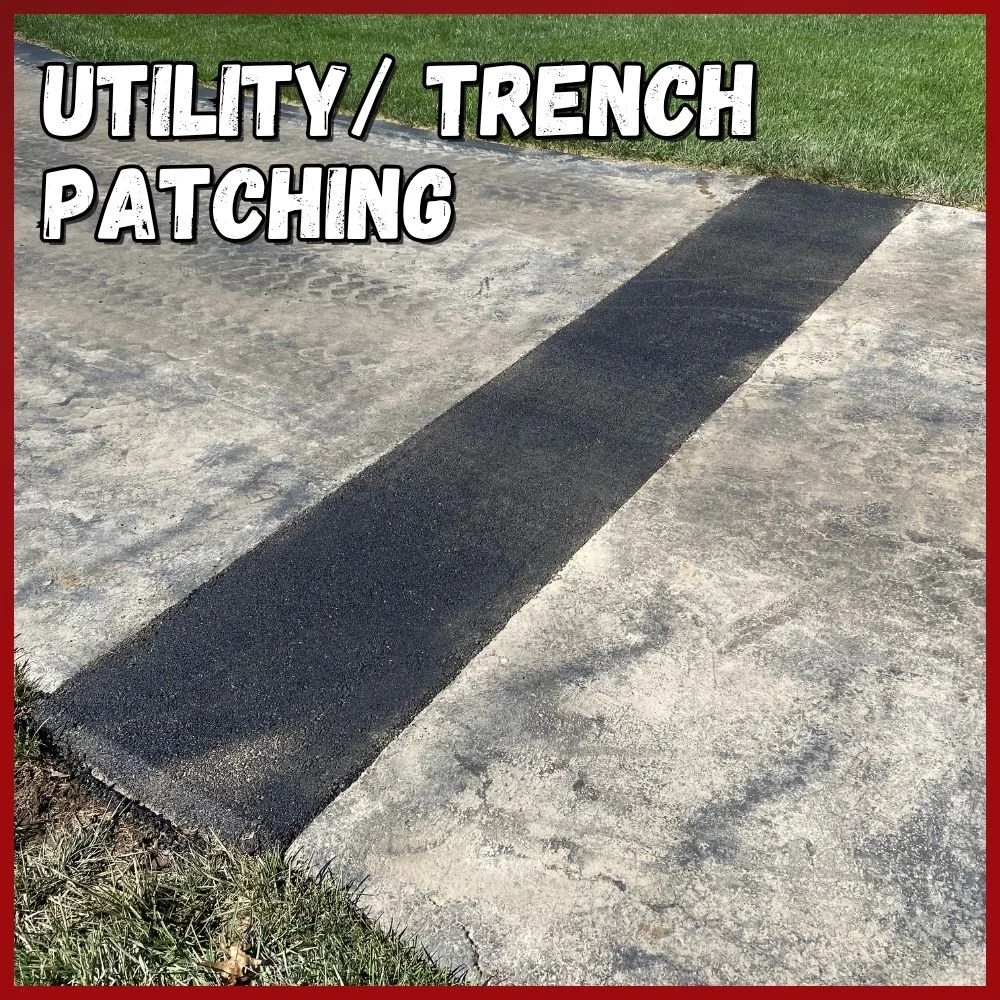 Utility and Trench patching text over a walking path that had a line cut out for sub ground work, a fresh asphalt strip lays where the repair was made. A darker black than the existing asphalt.