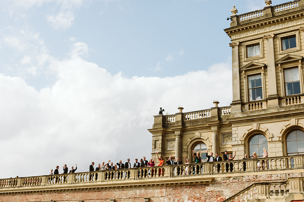 Group of people celebrating outside on the terrace at Cliveden House, UK.