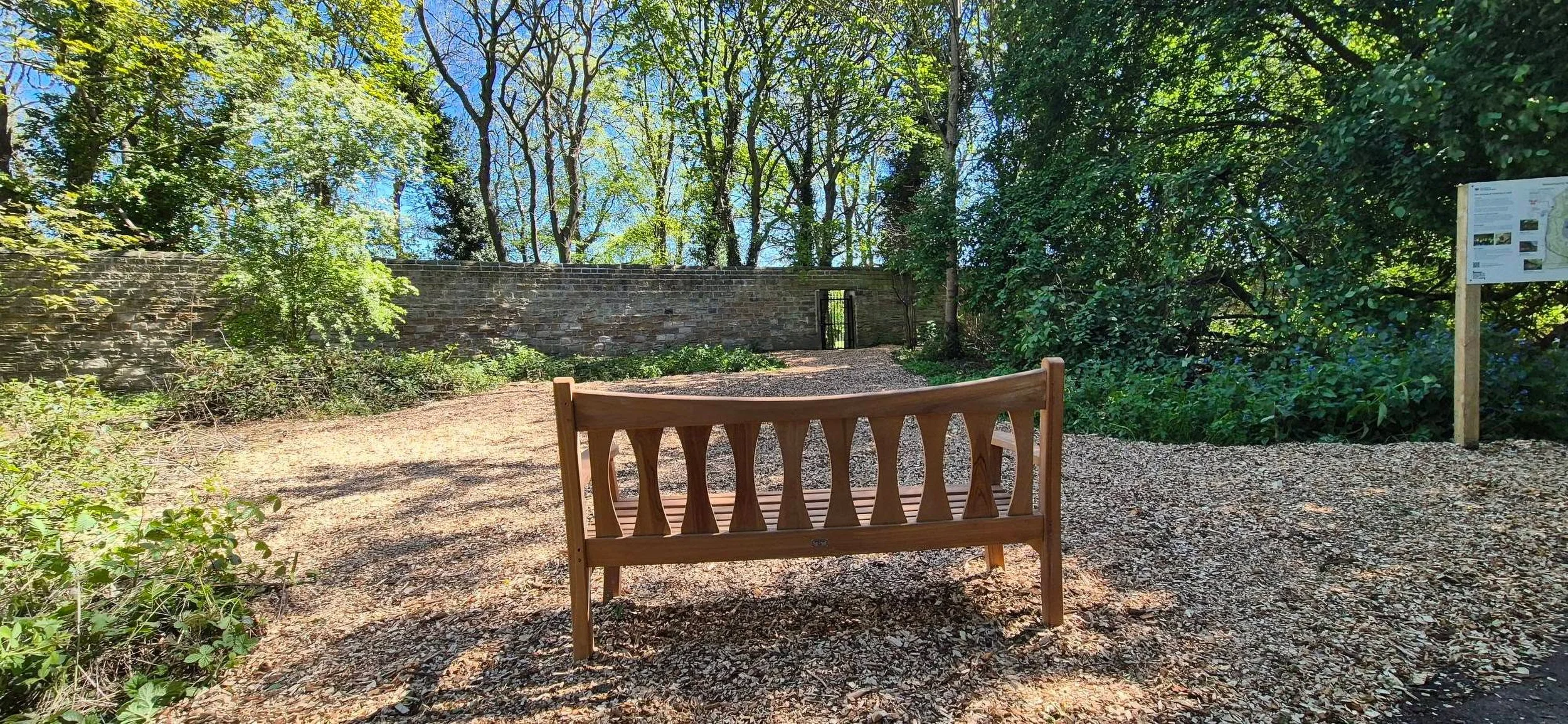 A bench placed at the nest looking towards the repaired section of the stone wall.