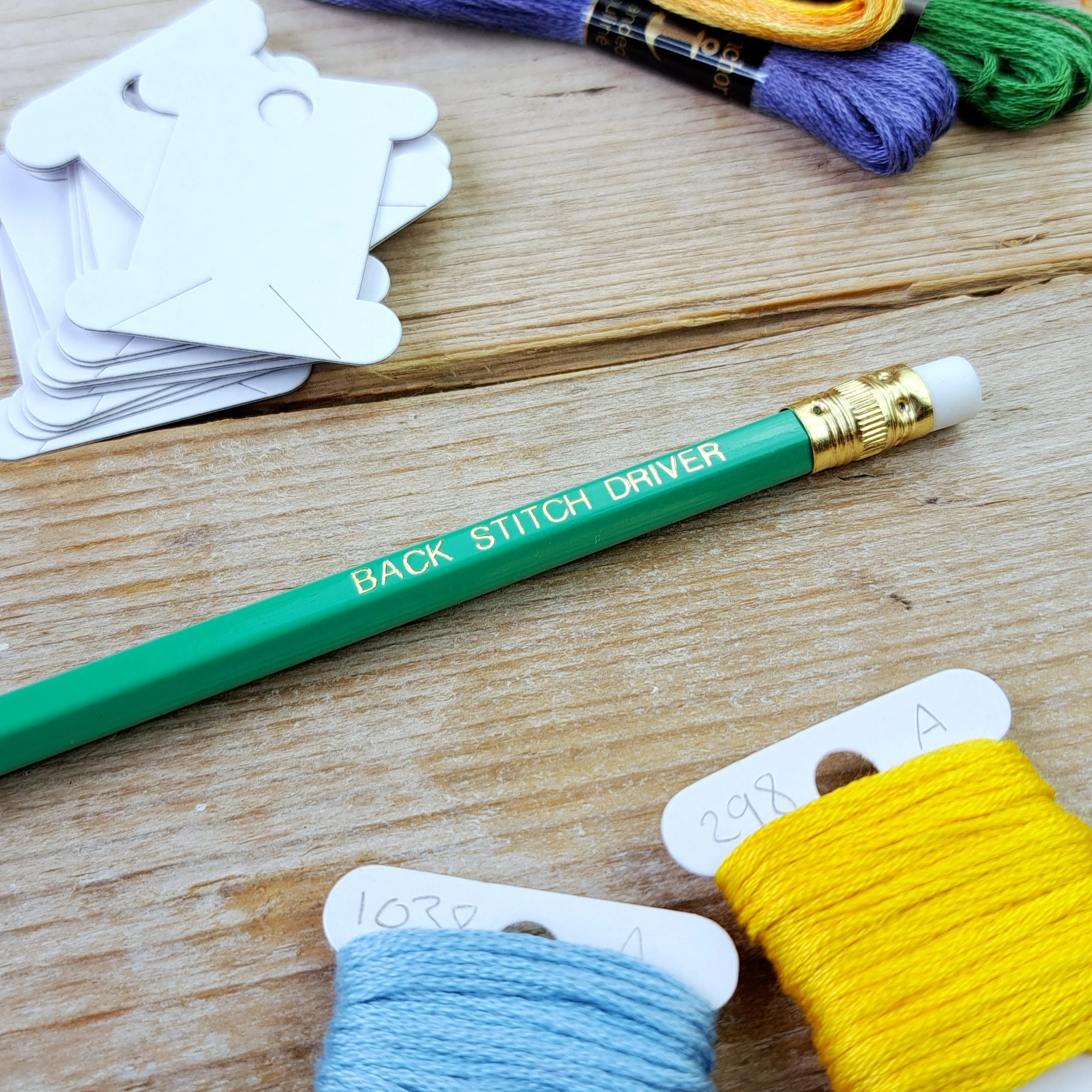 Green "Back Stitch Driver" HB pencil showing the gold foil slogan, gold ferrule and white eraser