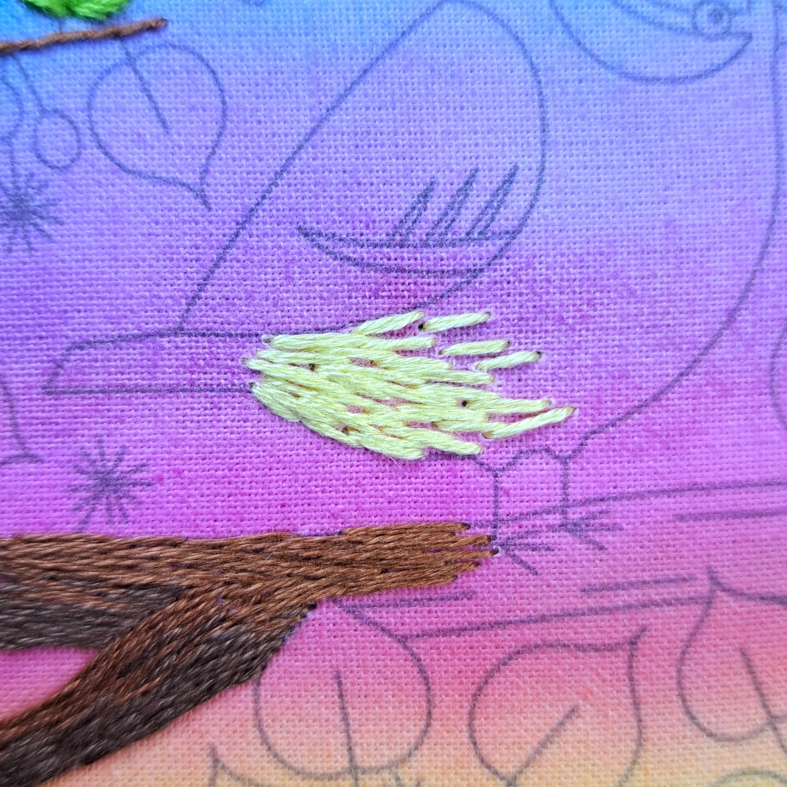 Close-up of the light yellow Long and Short Stitch used to embroider the feathers on the Blue Tits belly.