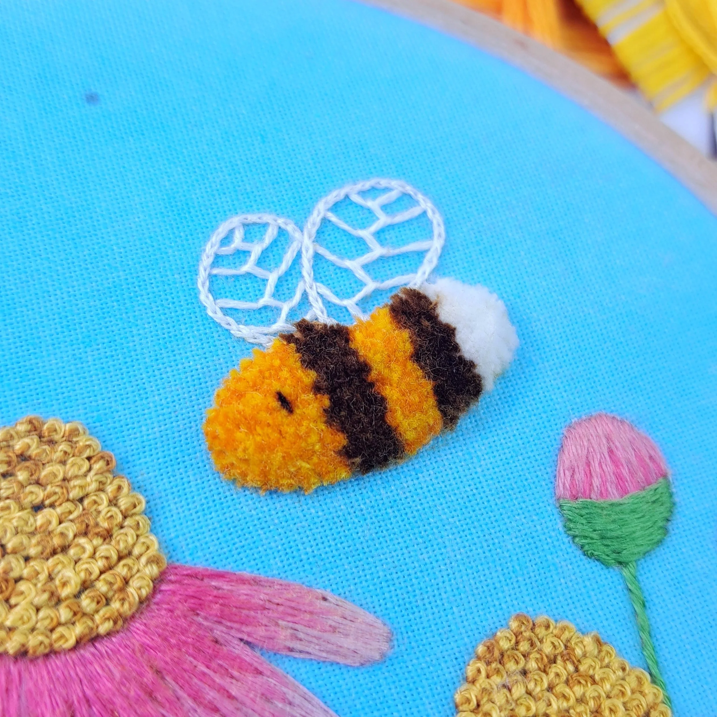 Close-up of the fully trimmed and shaped Turkey Stitch used to embroider the bees body.