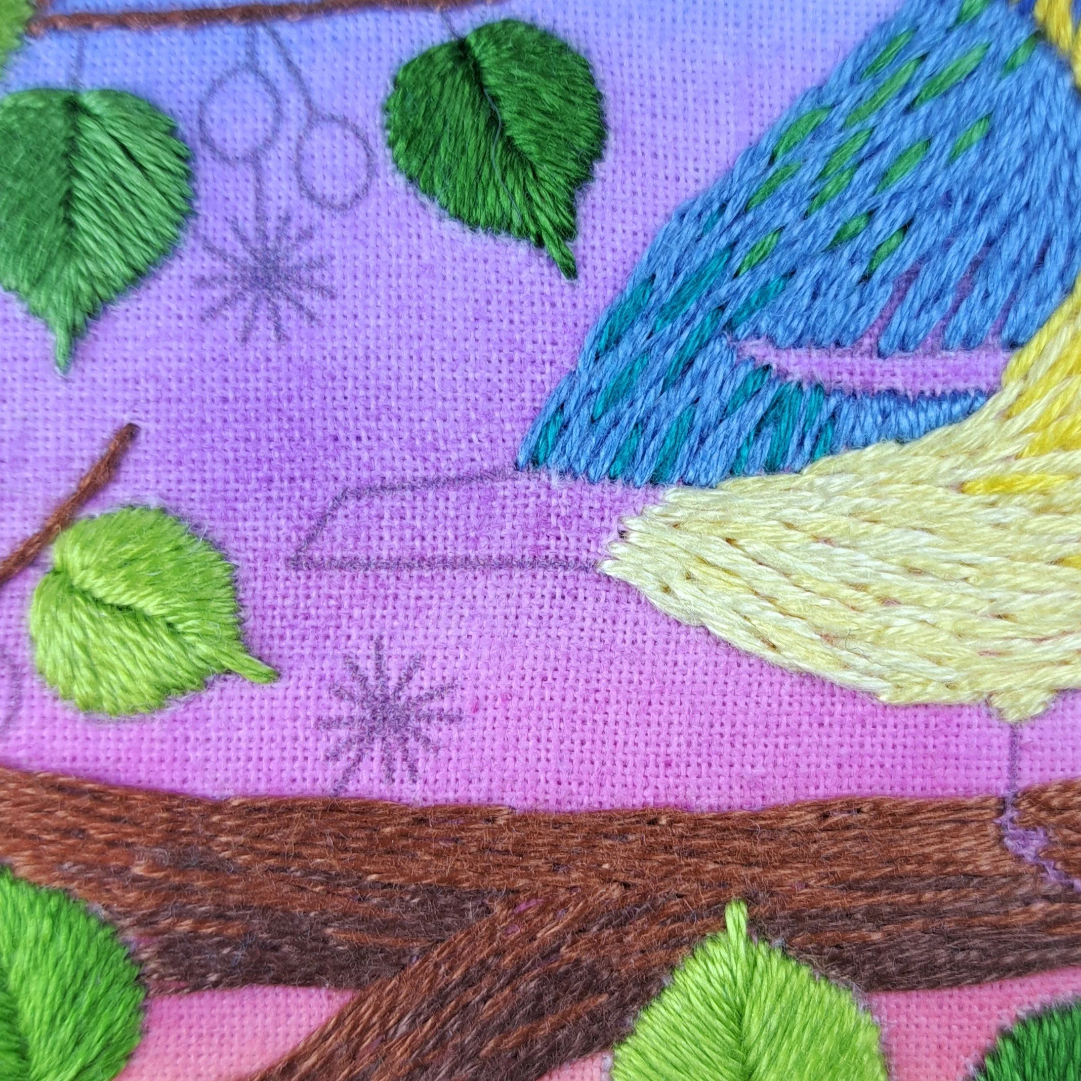 Close-up of the neatened light yellow Long and Short Stitch used to embroider the feathers at the start of the Blue Tits belly.