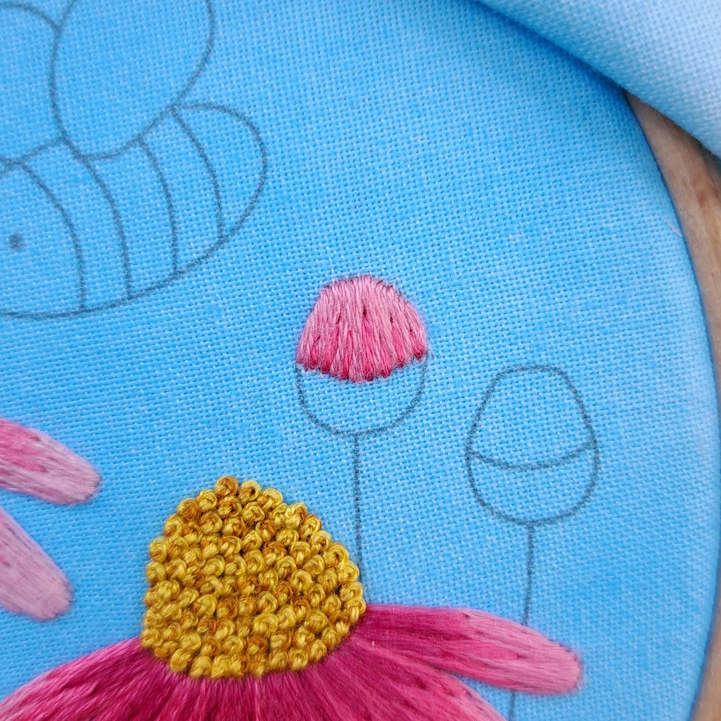 Close-up of the dark pink Straight Stitches added in to the top part of a flower bud.