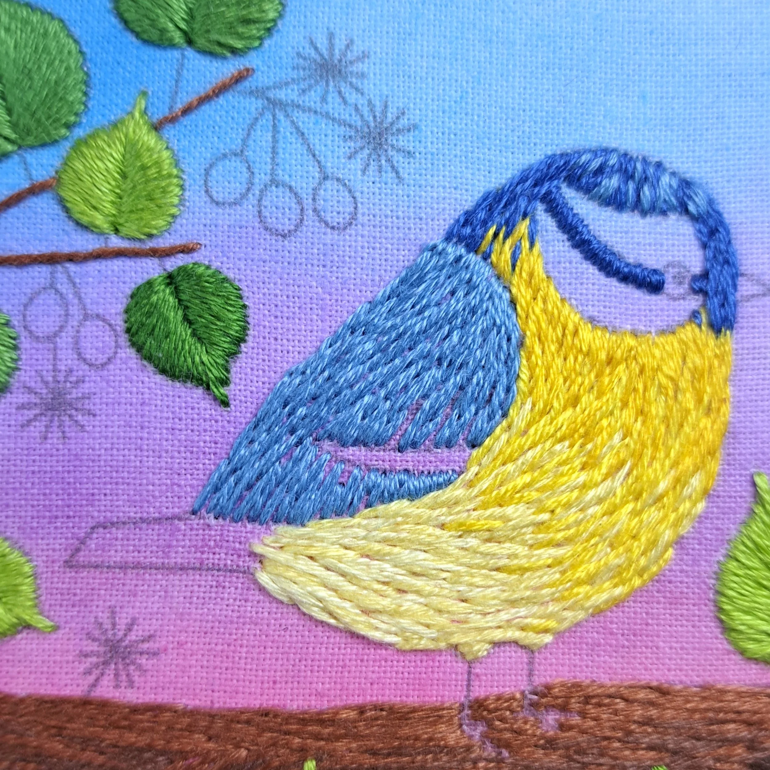 Close-up of the light blue Long and Short Stitch used to embroider the feathers on the Blue Tits wing.
