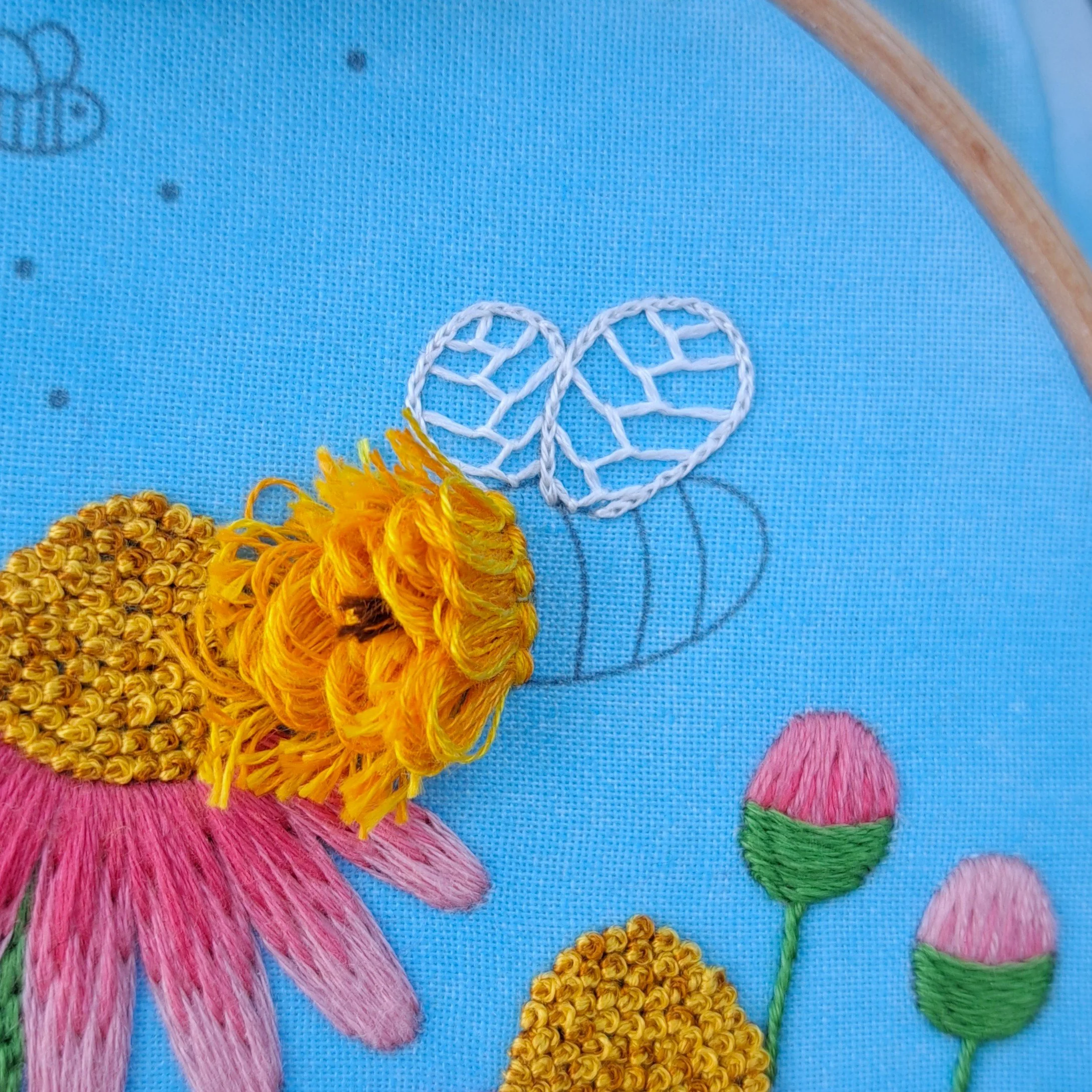 Close-up of the orange Turkey Stitch used to embroider the bees head.