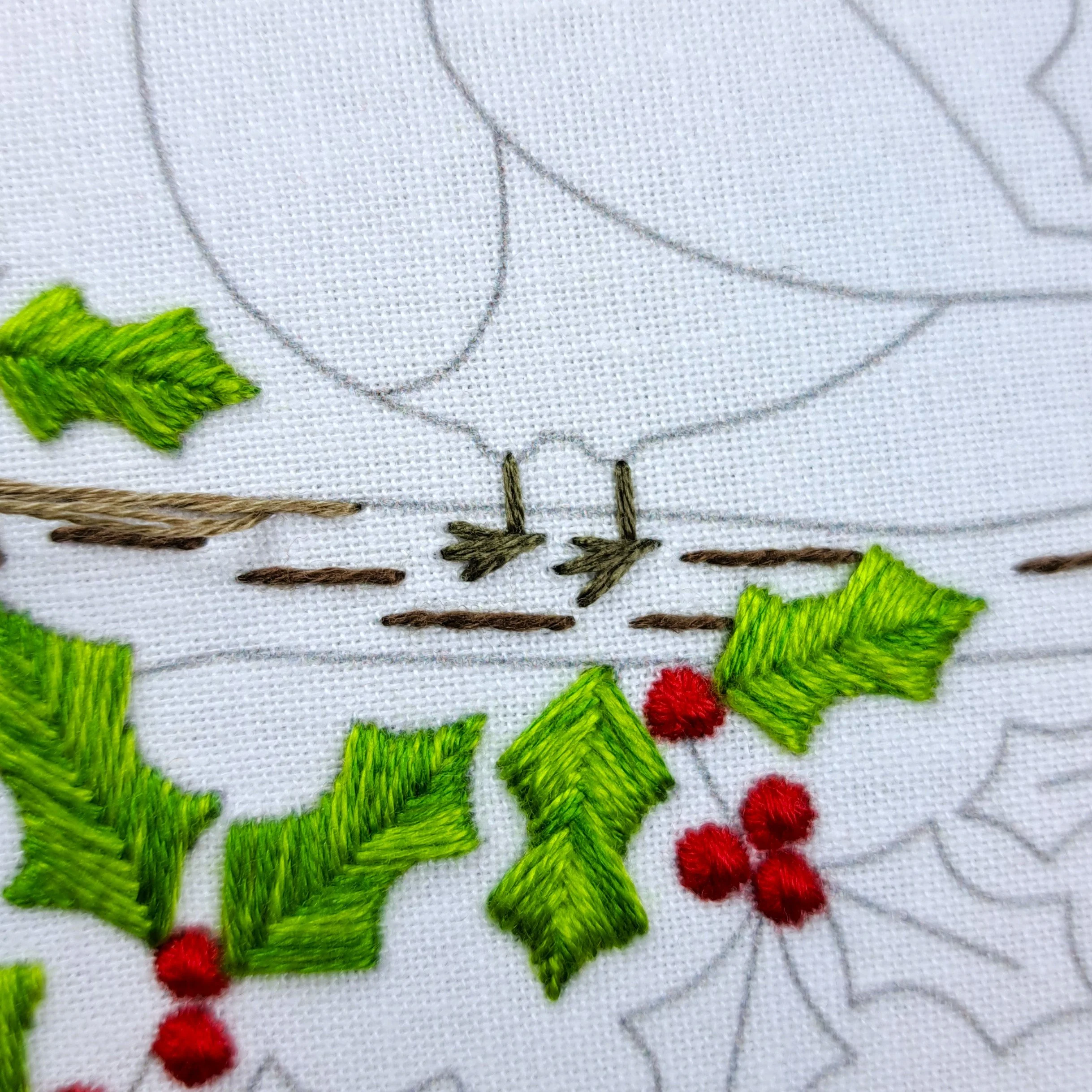 Close-up of completed brown Straight Stitches forming the robin’s legs and feet.