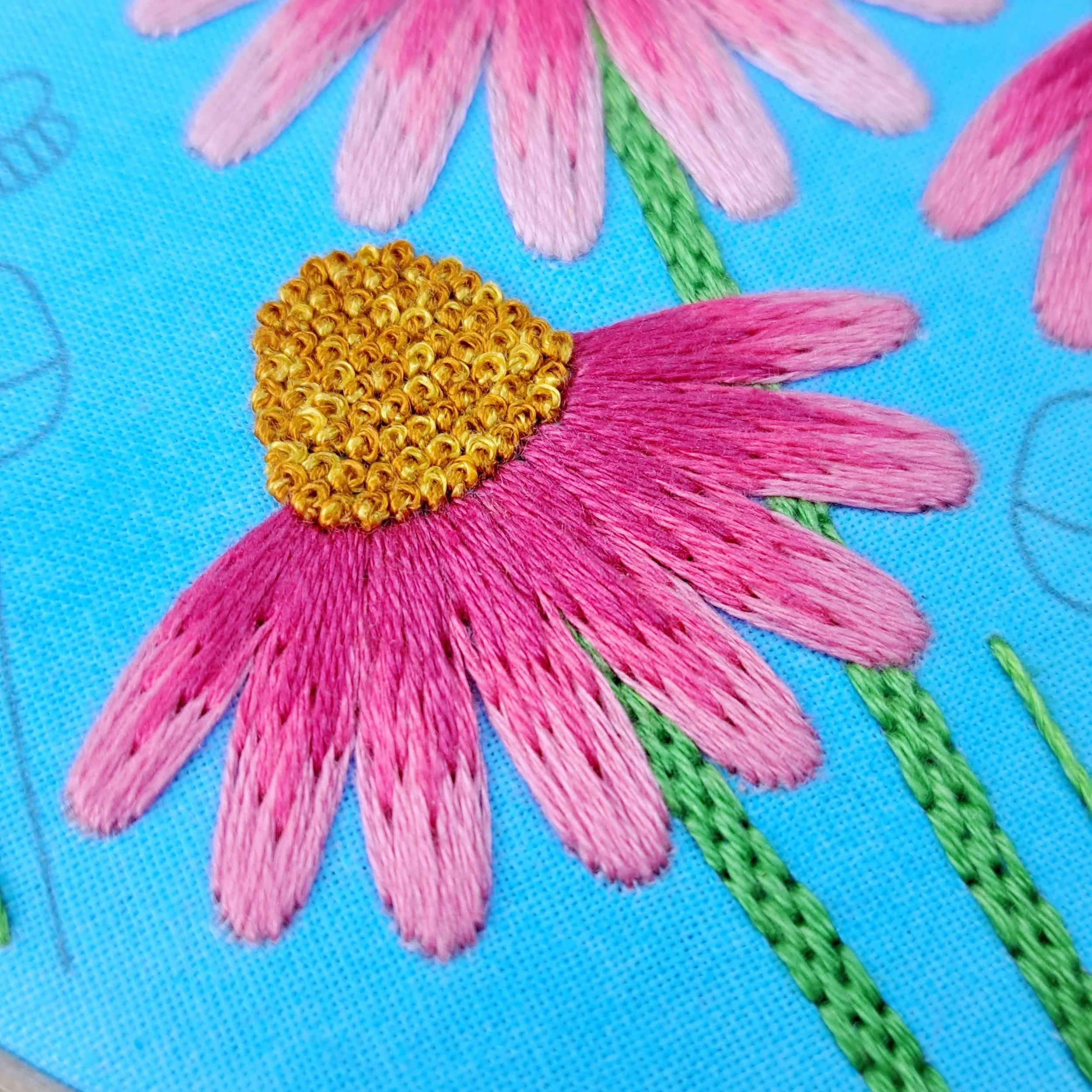 Close-up of the Satin Stitch used to embroider the left side Echinacea flower petals. These flower petals are stitched in the same way as the middle flower, but uses darker shades of pink.