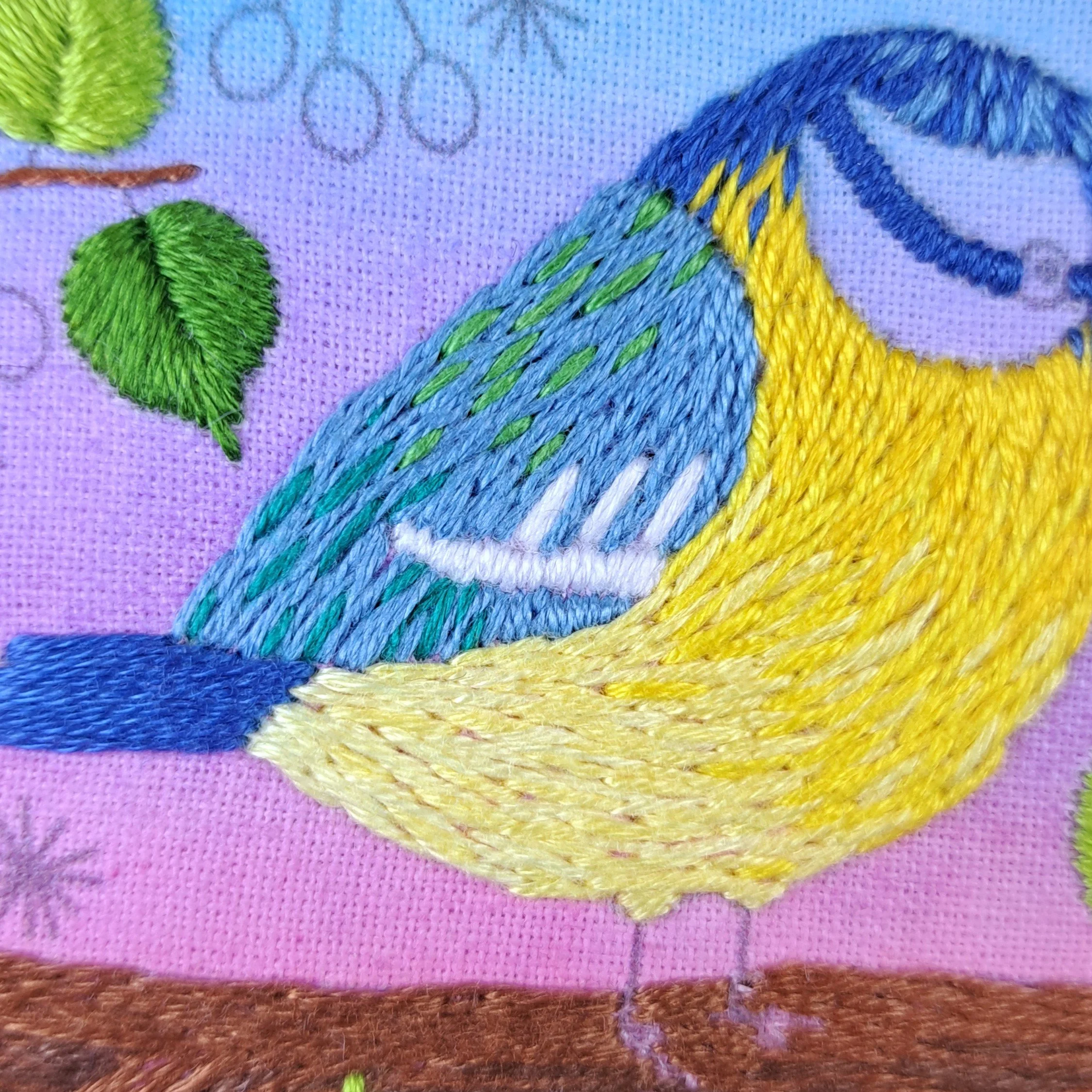 Close-up of the white Satin Stitches used to embroider the horizontal markings on the Blue Tits wing.