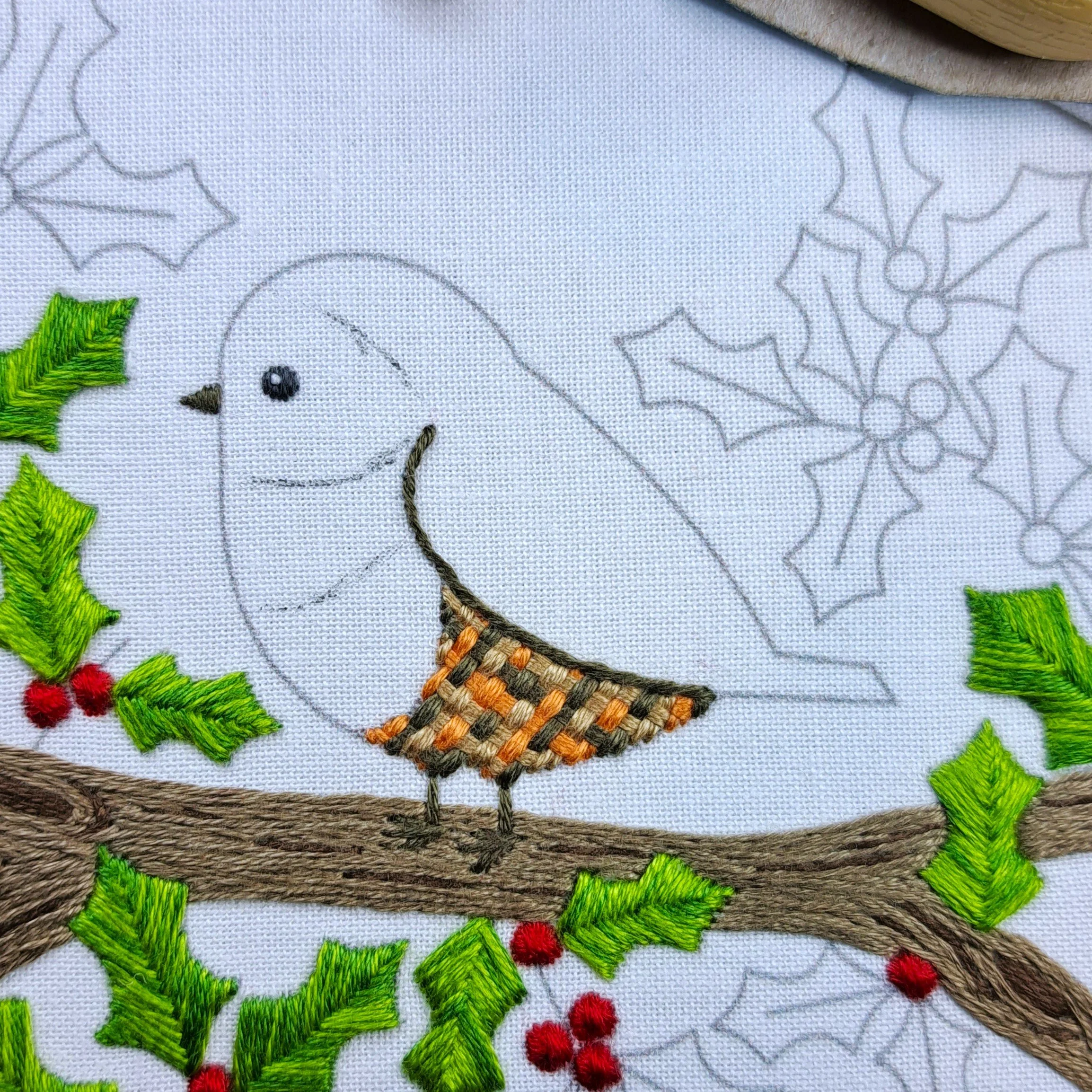 Close-up of fabric pen lines marking colour bands on the robin before stitching.