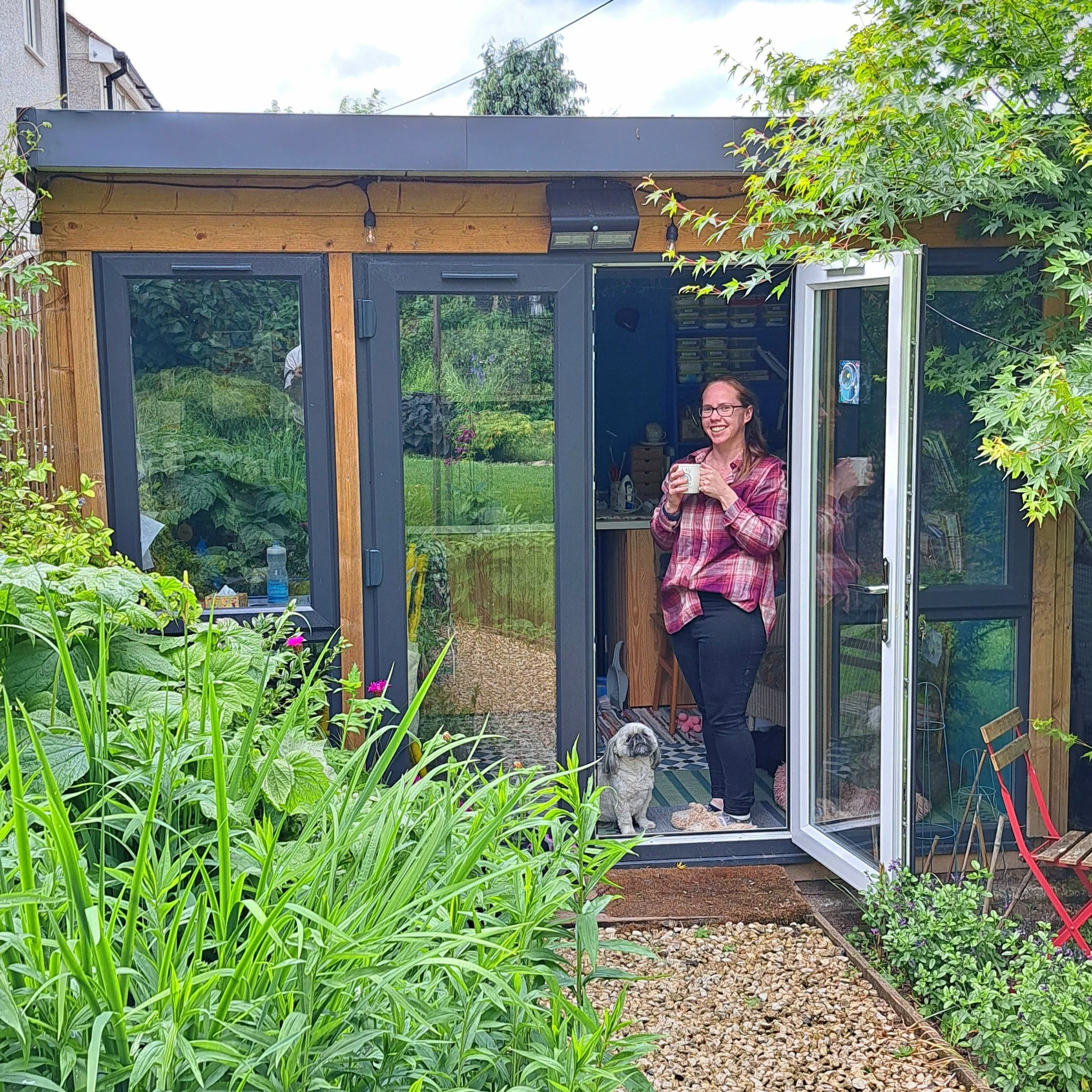 Liz and her dog Bessie outside the Bluebell Love garden studio on Dartmoor