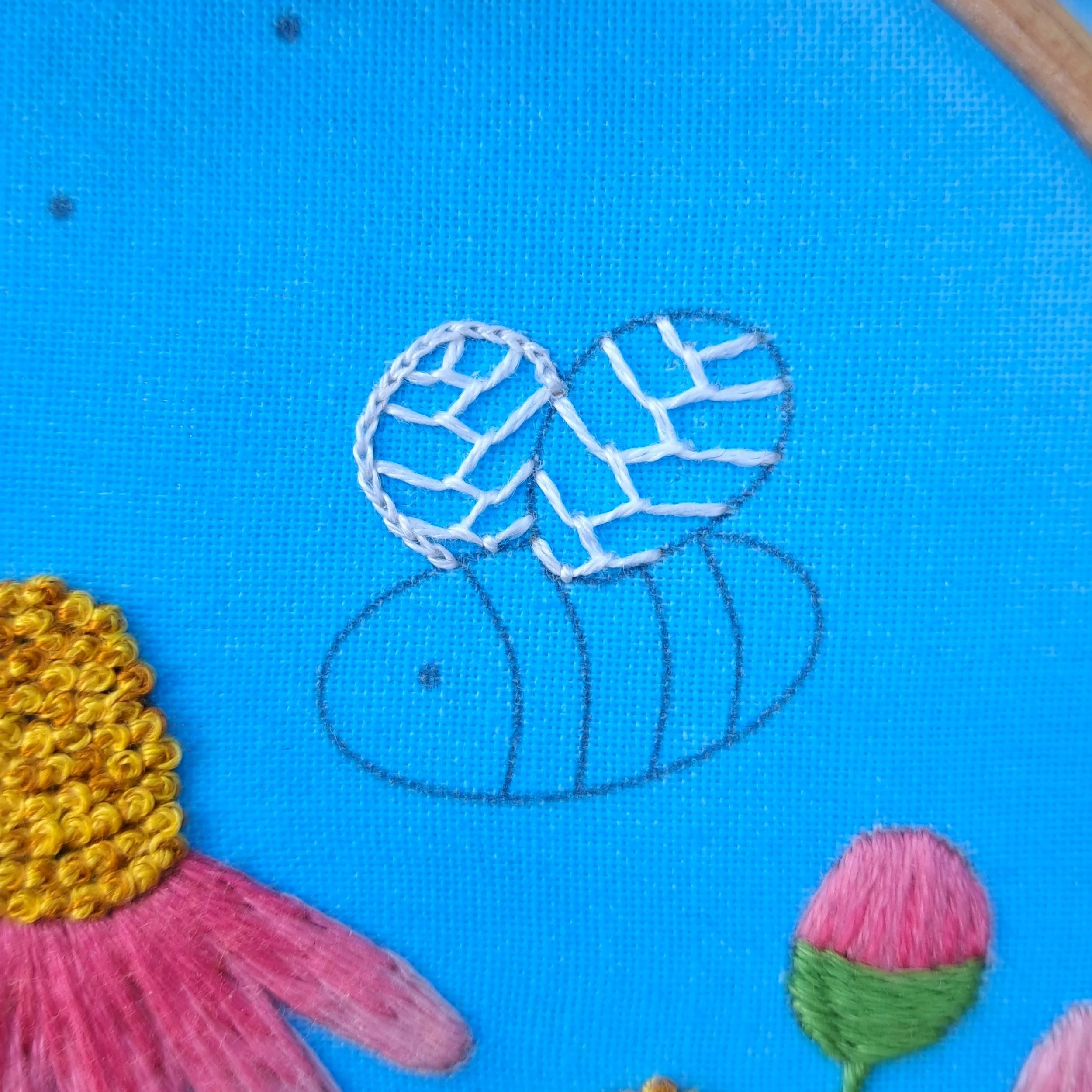 Close-up of the white Split Stitch used to embroider the outline of the back bee wing.