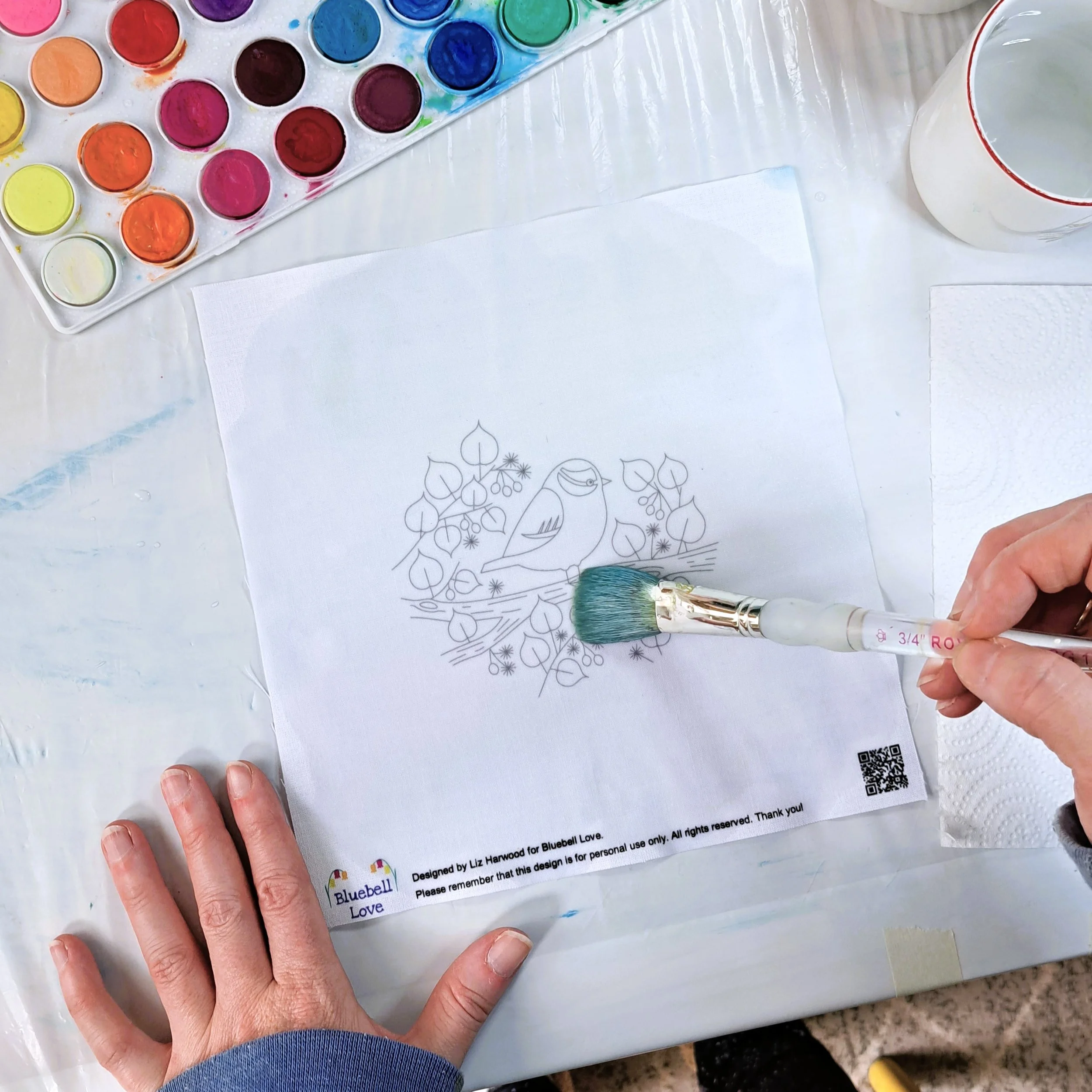 My hand painting using a large round brush to wet the entire fabric embroidery panel with clean water.