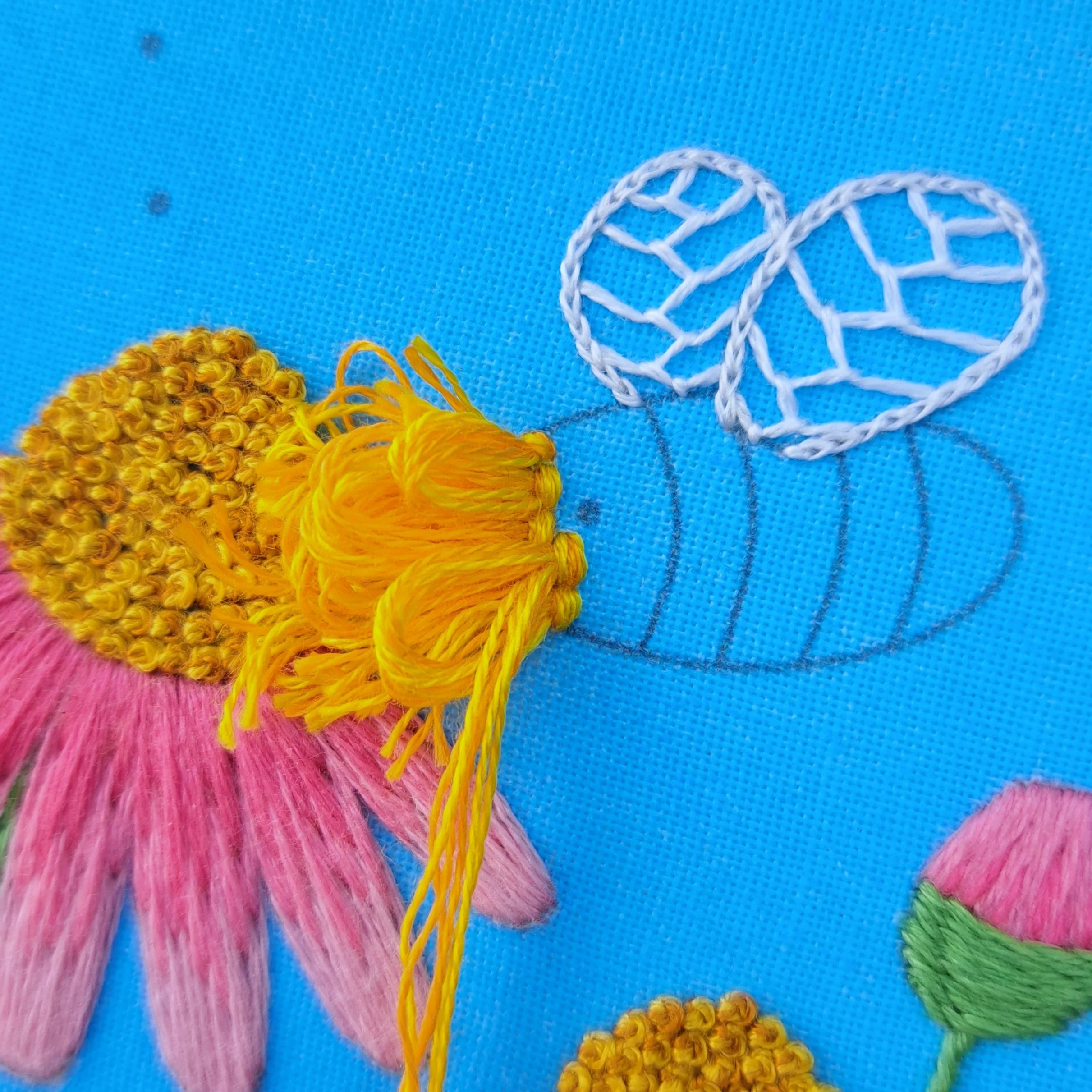 Close-up of the first rows of orange Turkey Stitch used to embroider the bees body.