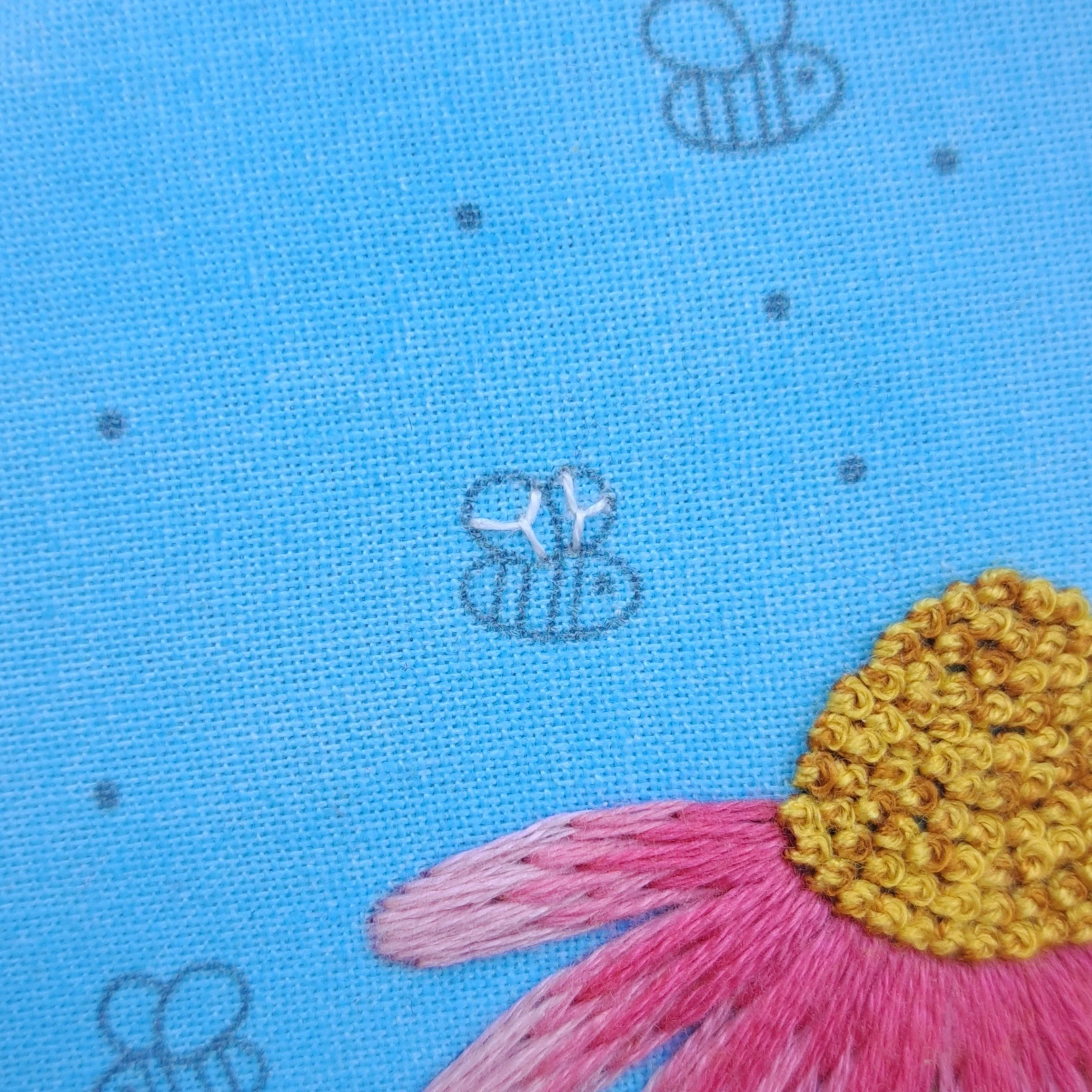 Close-up of the white Fly Stitch used to embroider the smaller bees wing.