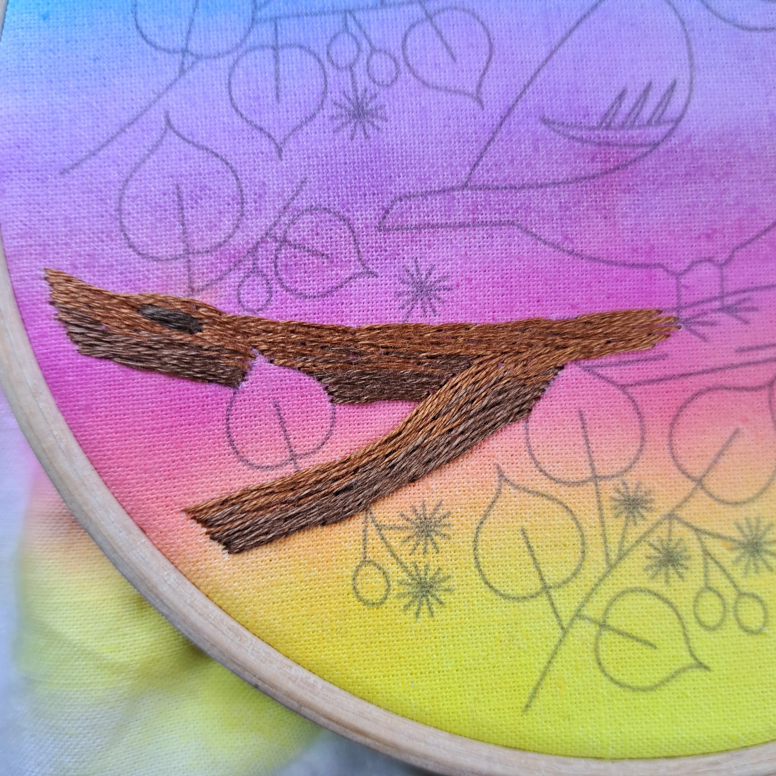 Close-up of the brown Long and Short Stitch used to embroider the bark on the bottom half of the tree branch.