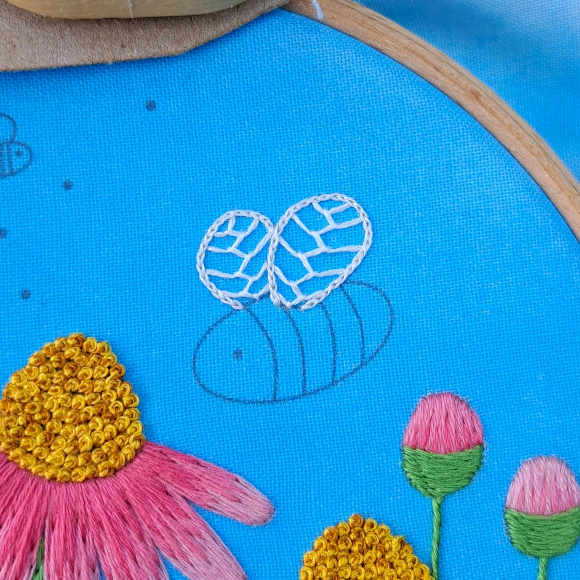 Close-up of the white Split Stitch used to embroider the outline of the bee wings.