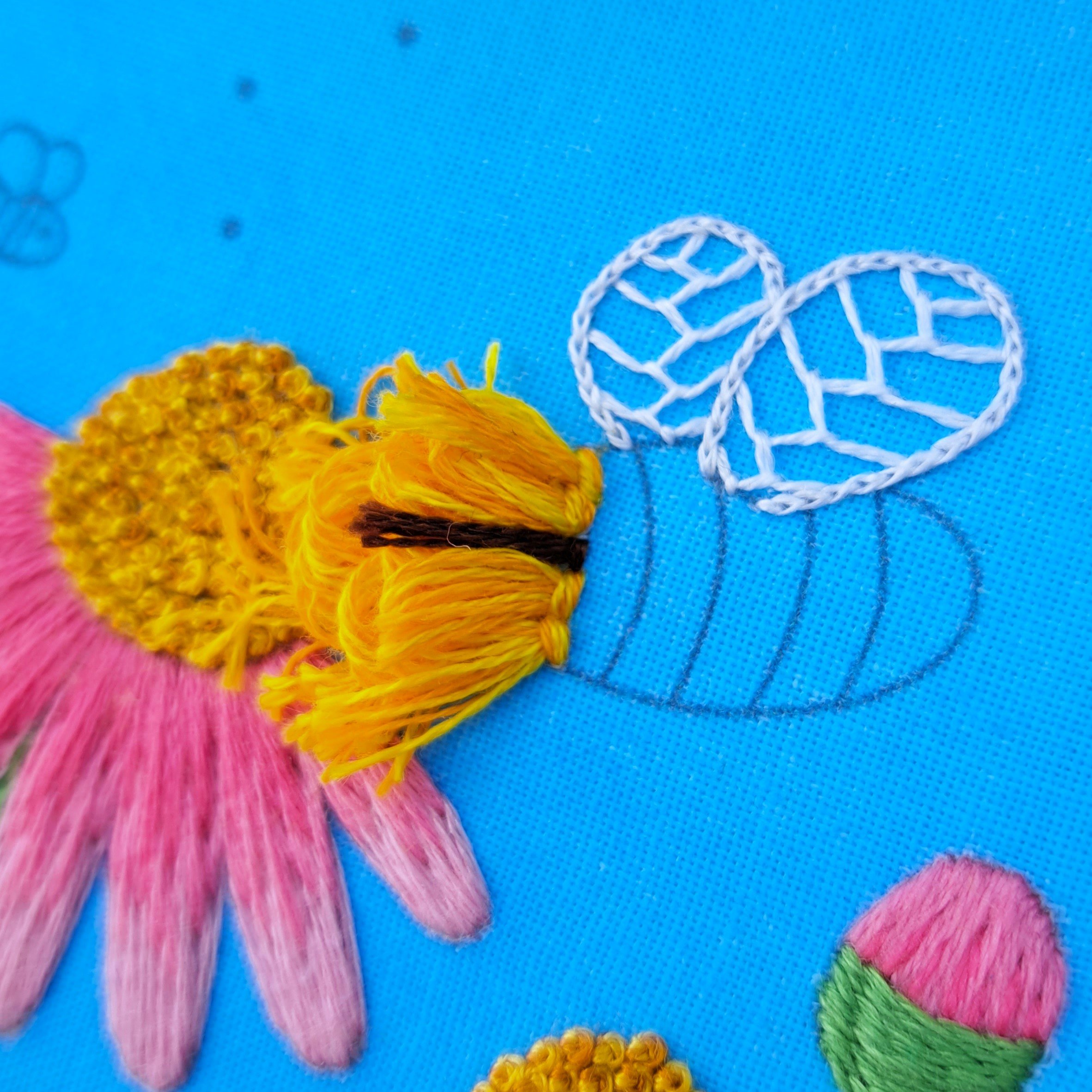 Close-up of the single brown Turkey Stitch used to embroider the bees eye.