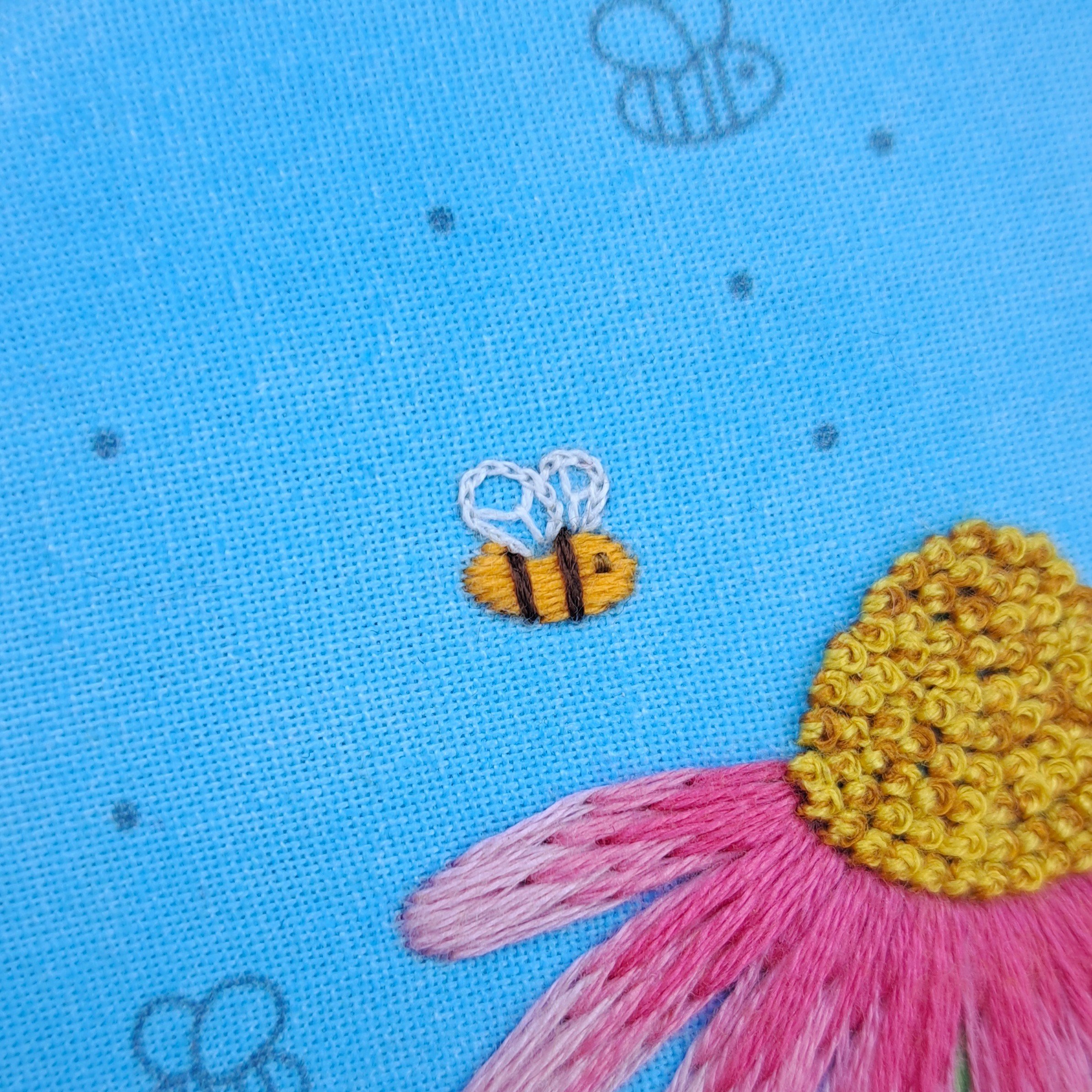 Close-up of the brown Couch Stitch used to embroider the smaller bees eye.