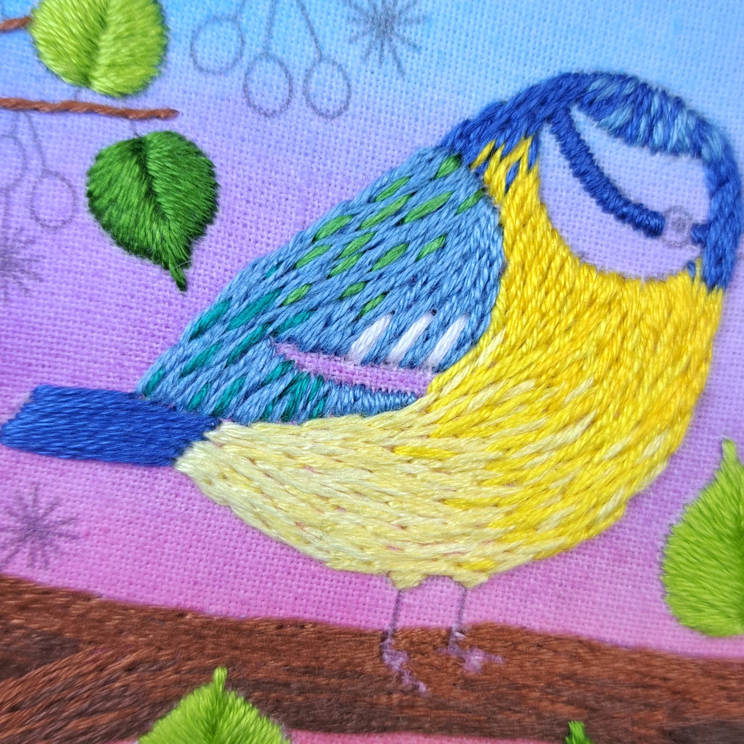 Close-up of the white Straight Stitches used to embroider the vertical markings on the Blue Tits wing.