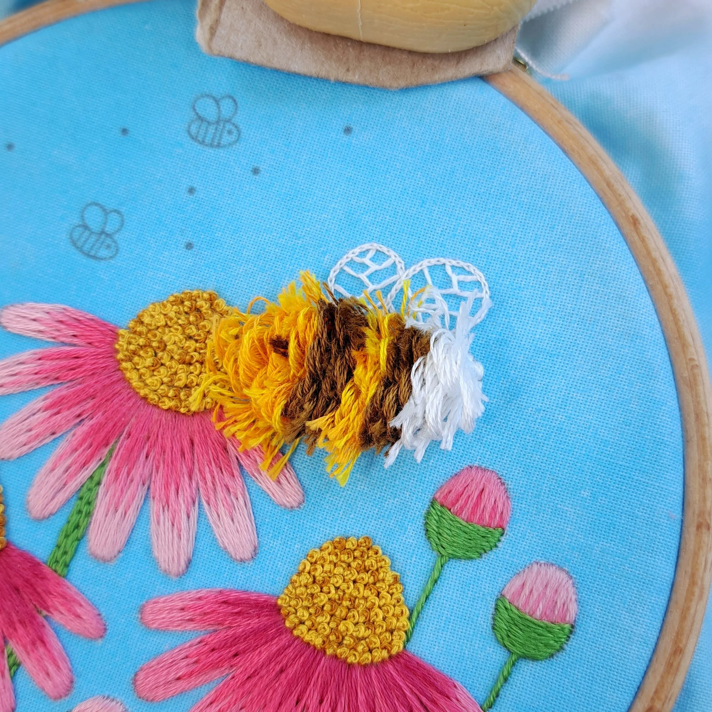 Close-up of the orange, brown and white Turkey Stitch used to embroider the bees body.
