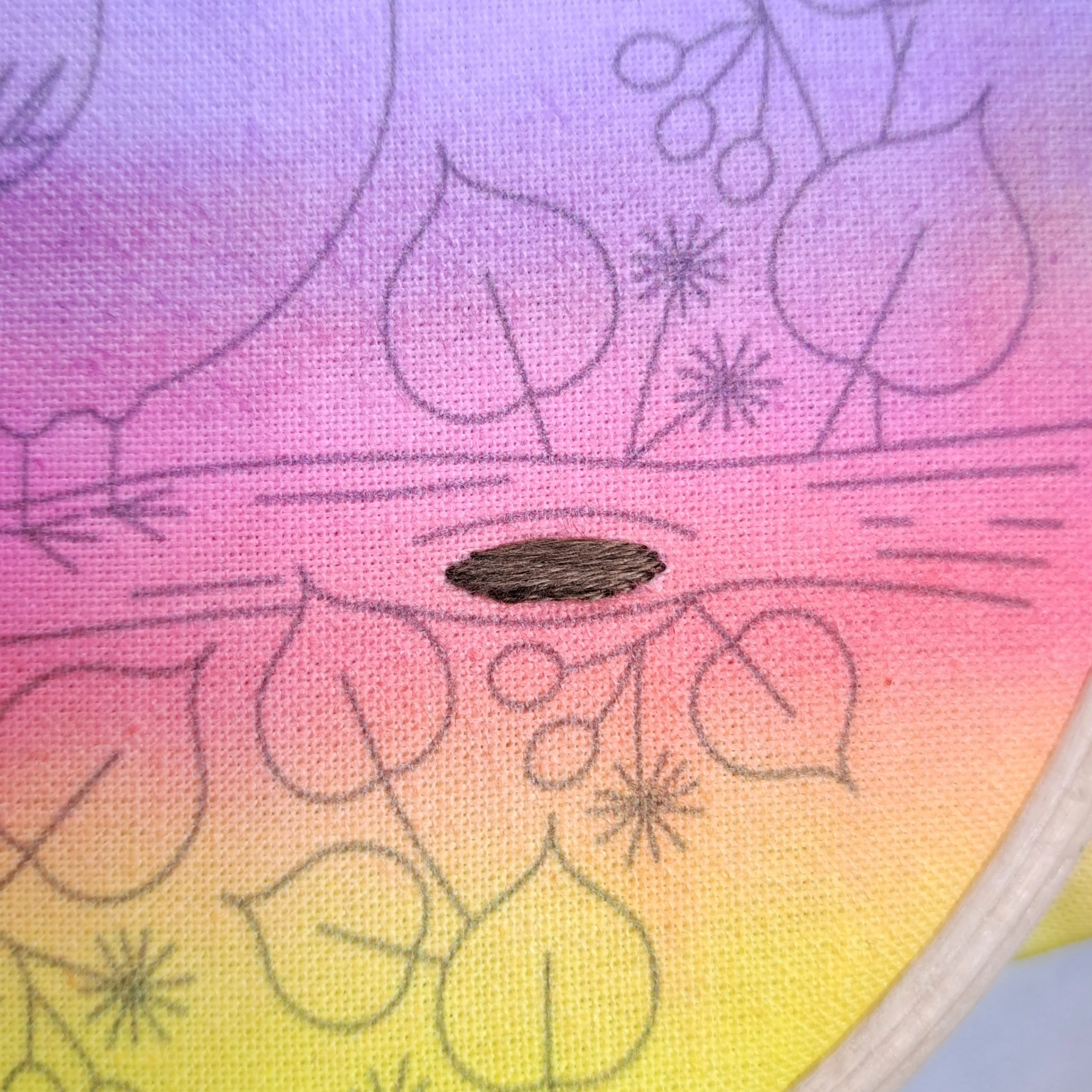 Close-up of the dark brown Satin Stitch used to embroider the knots on the tree branch.