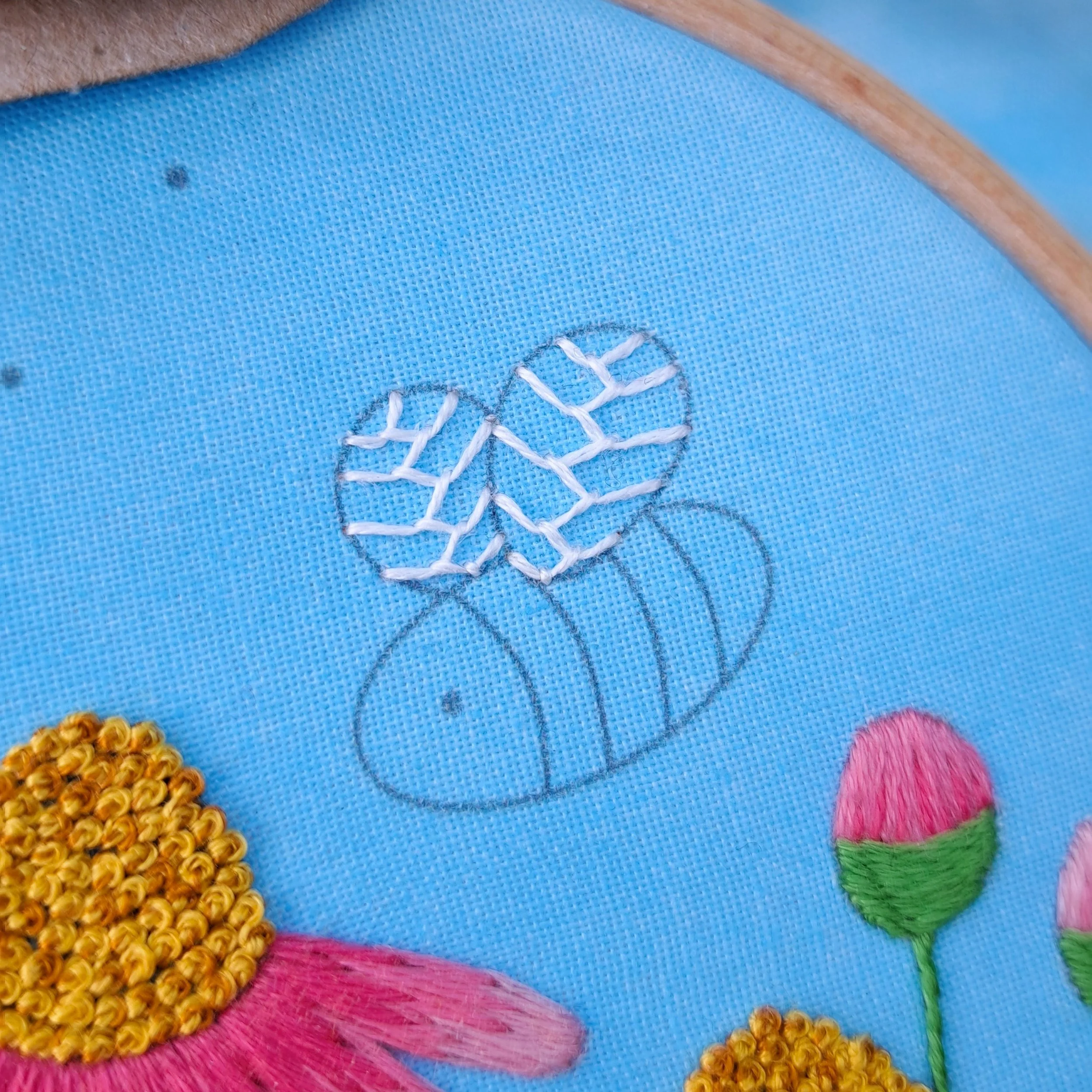 Close-up of the white Feather Stitch used to embroider the bee wings.