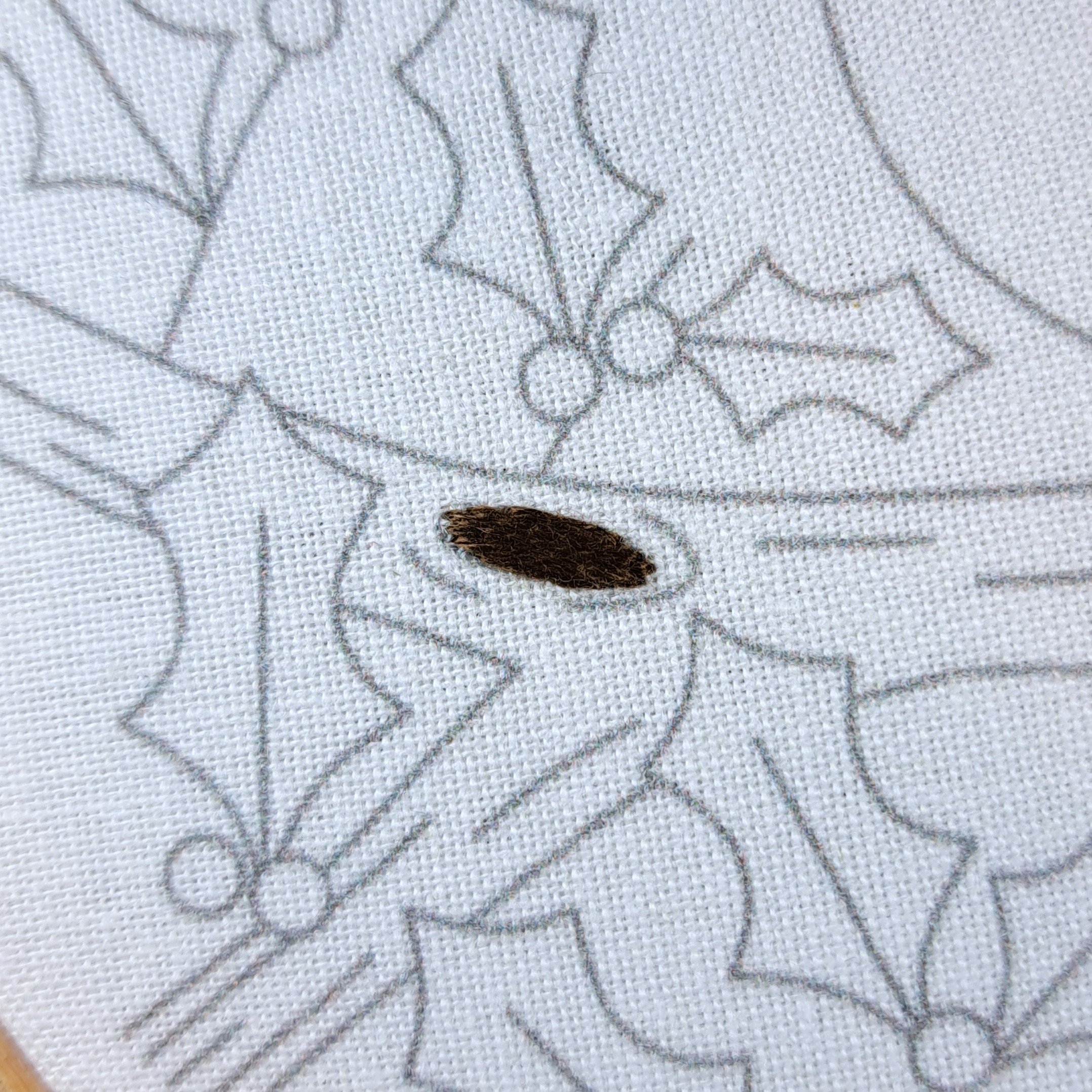 Close-up of dark brown Satin Stitch filling a knot on the tree branch.