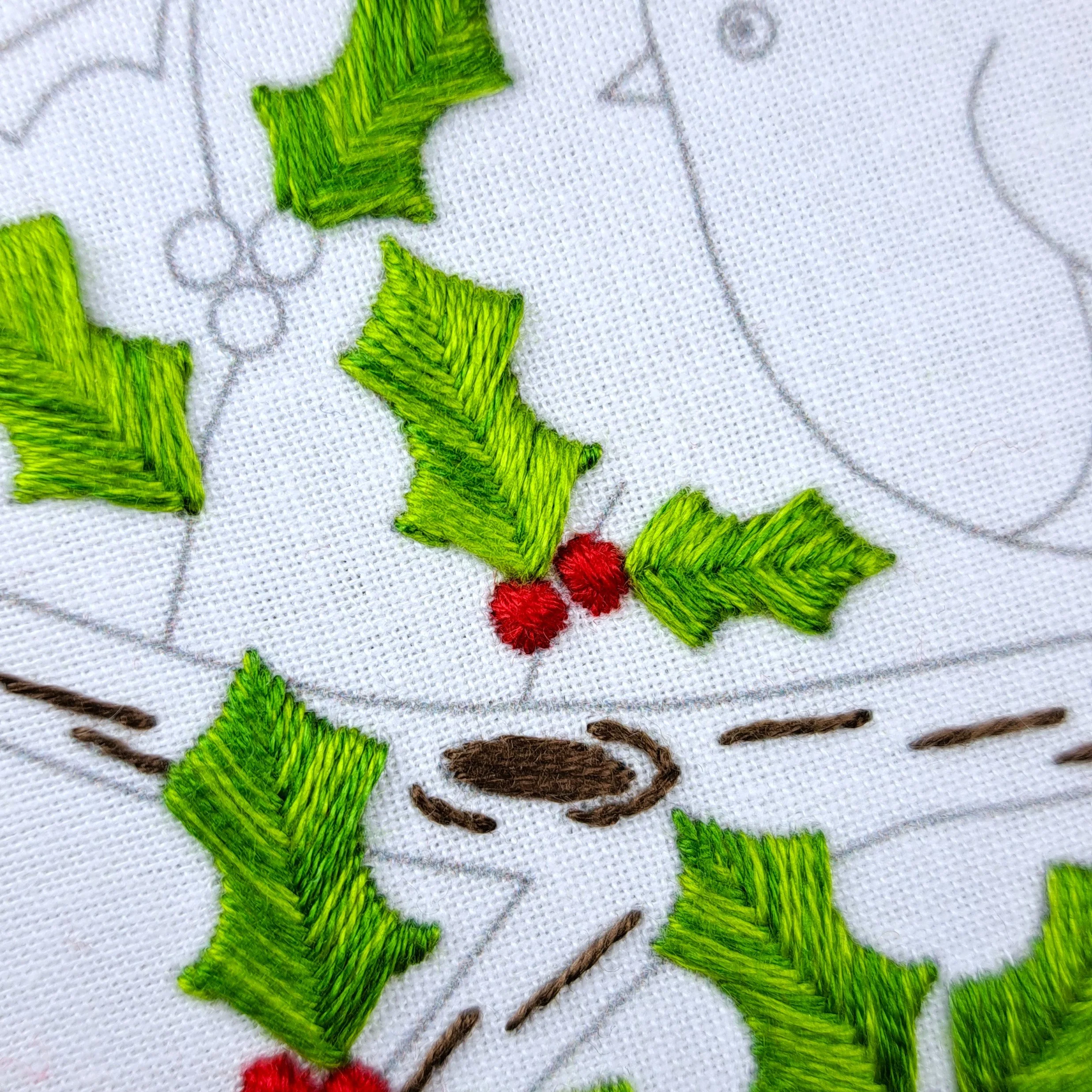 Close-up of a fully stitched red holly berry using Rhodes Circle Stitch.