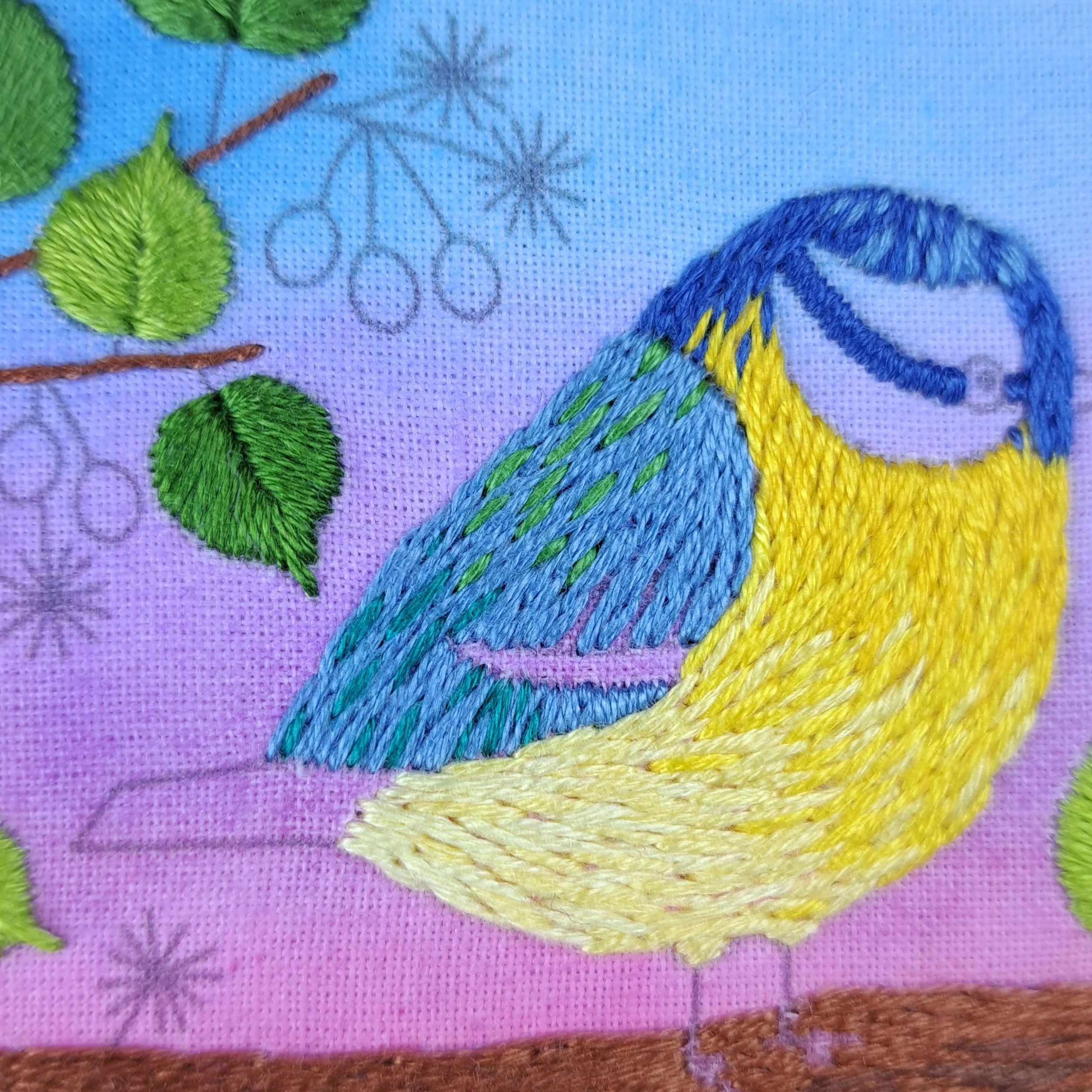 Close-up of the teal and green Straight Stitches used to embroider some feathers on the Blue Tits wing.