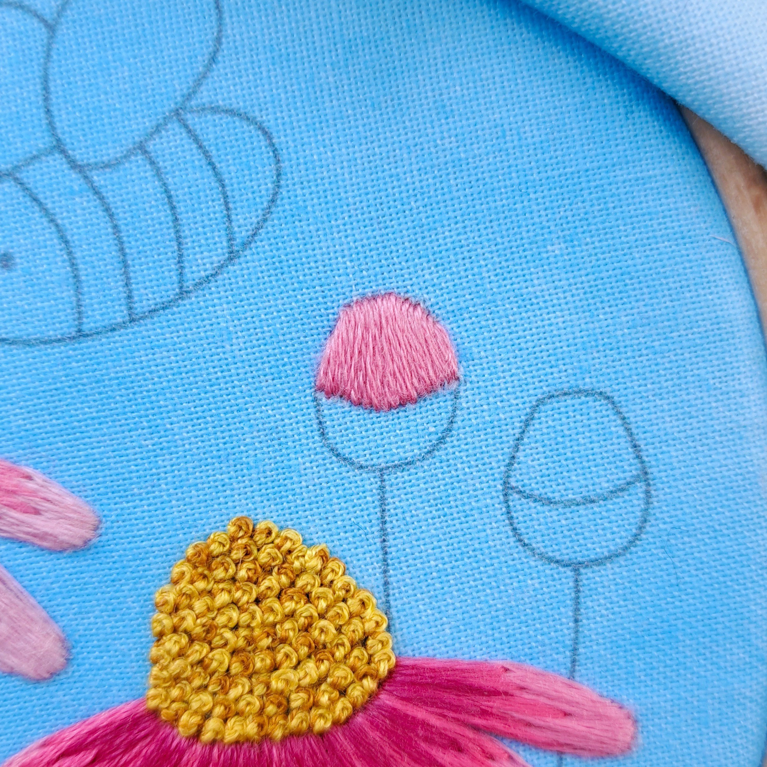 Close-up of the pink Satin Stitch used to embroider on the top part of a flower bud.