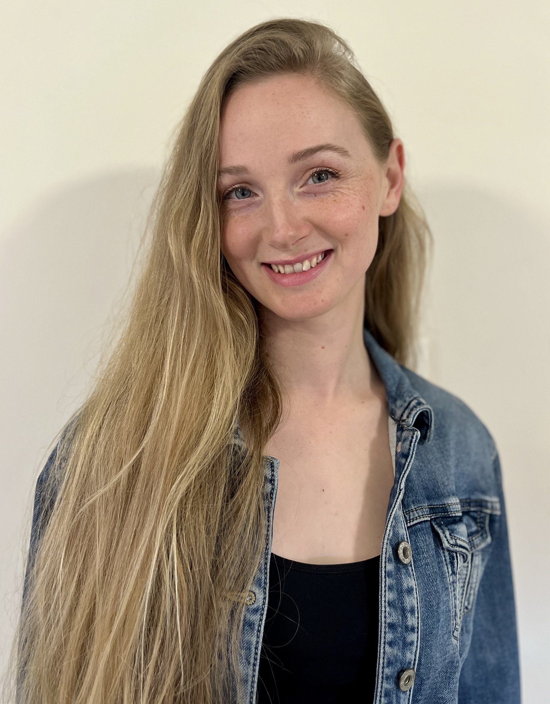 A young woman with long blonde hair, blue eyes, freckles. Hannah.