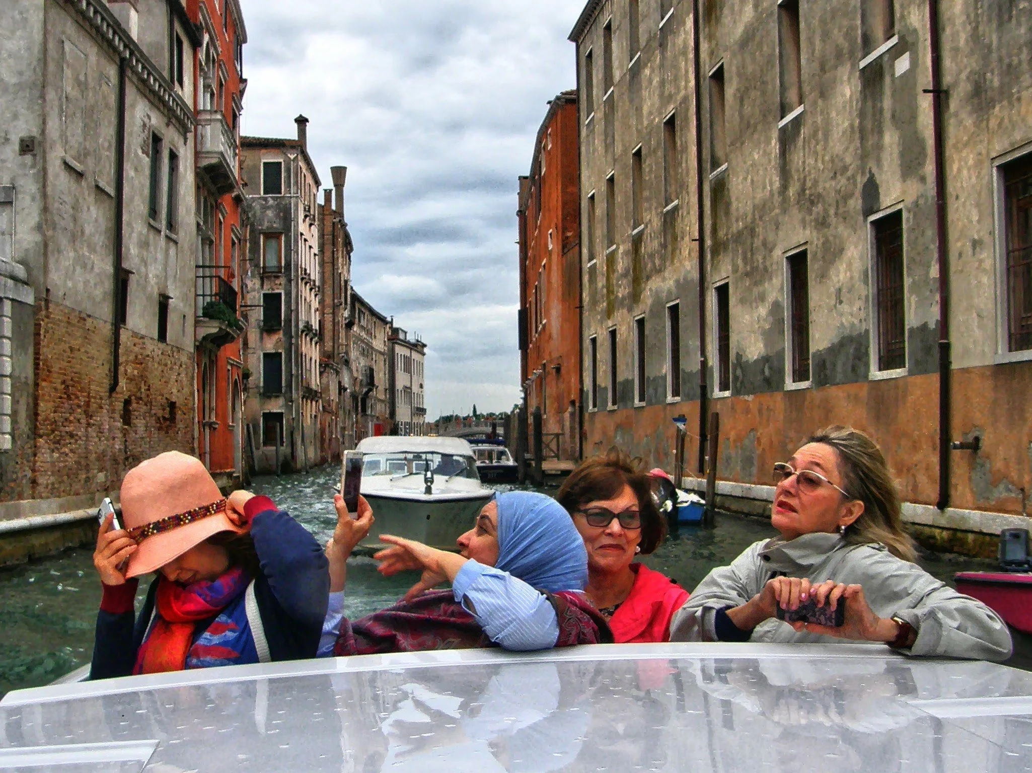  A few tourists snapping pictures from a water taxi 
