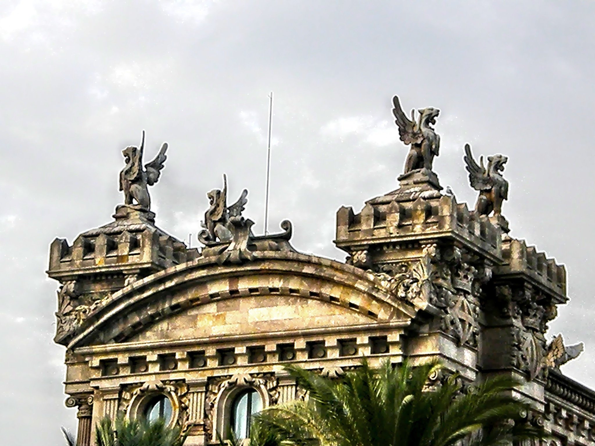  Four stone griffins on a rooftop guard the Port of Barcelona.  