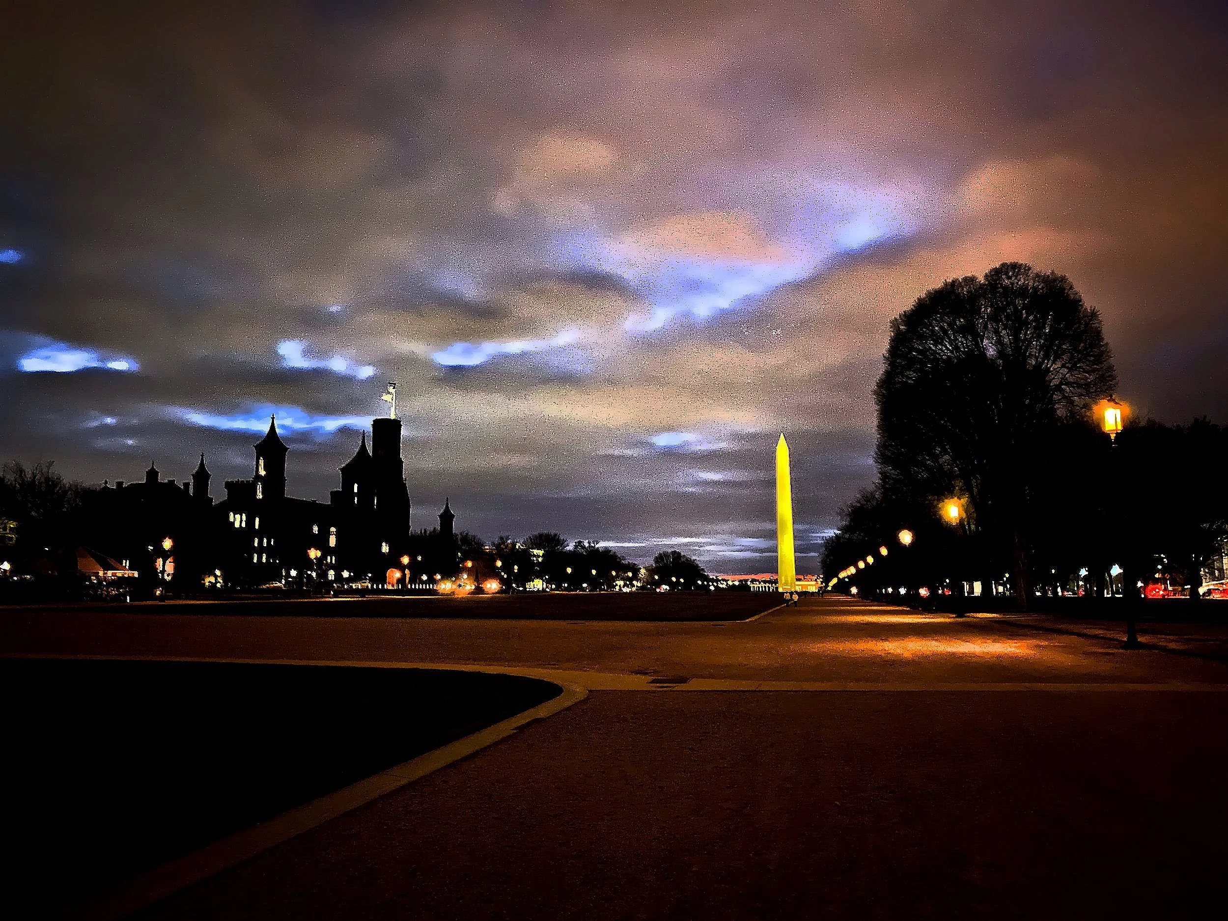  The sunset sky over the National Mall with the Washington monument and the outline of the Smithsonian Castle. 