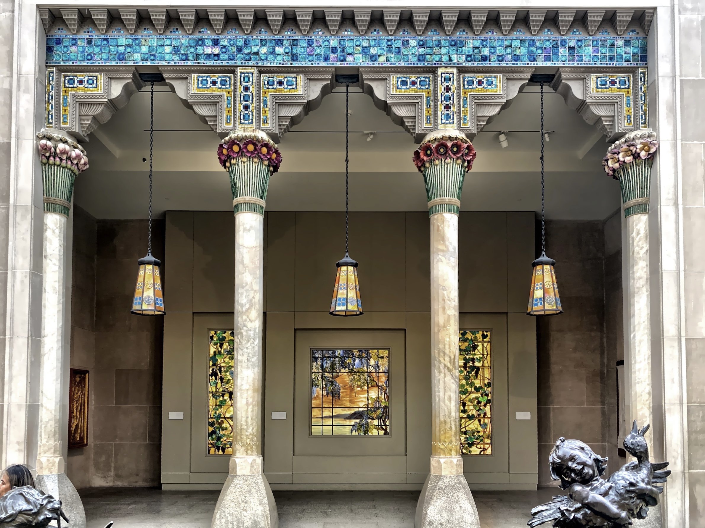  This is an architectural element from the Louis Comfort Tiffany’s Laurelton Hall in Oyster Bay, NY.  It served as the entrance to his mansion.  There are three stained glass pieces, in the exhibit, as well and the three glass shades hanging in the a