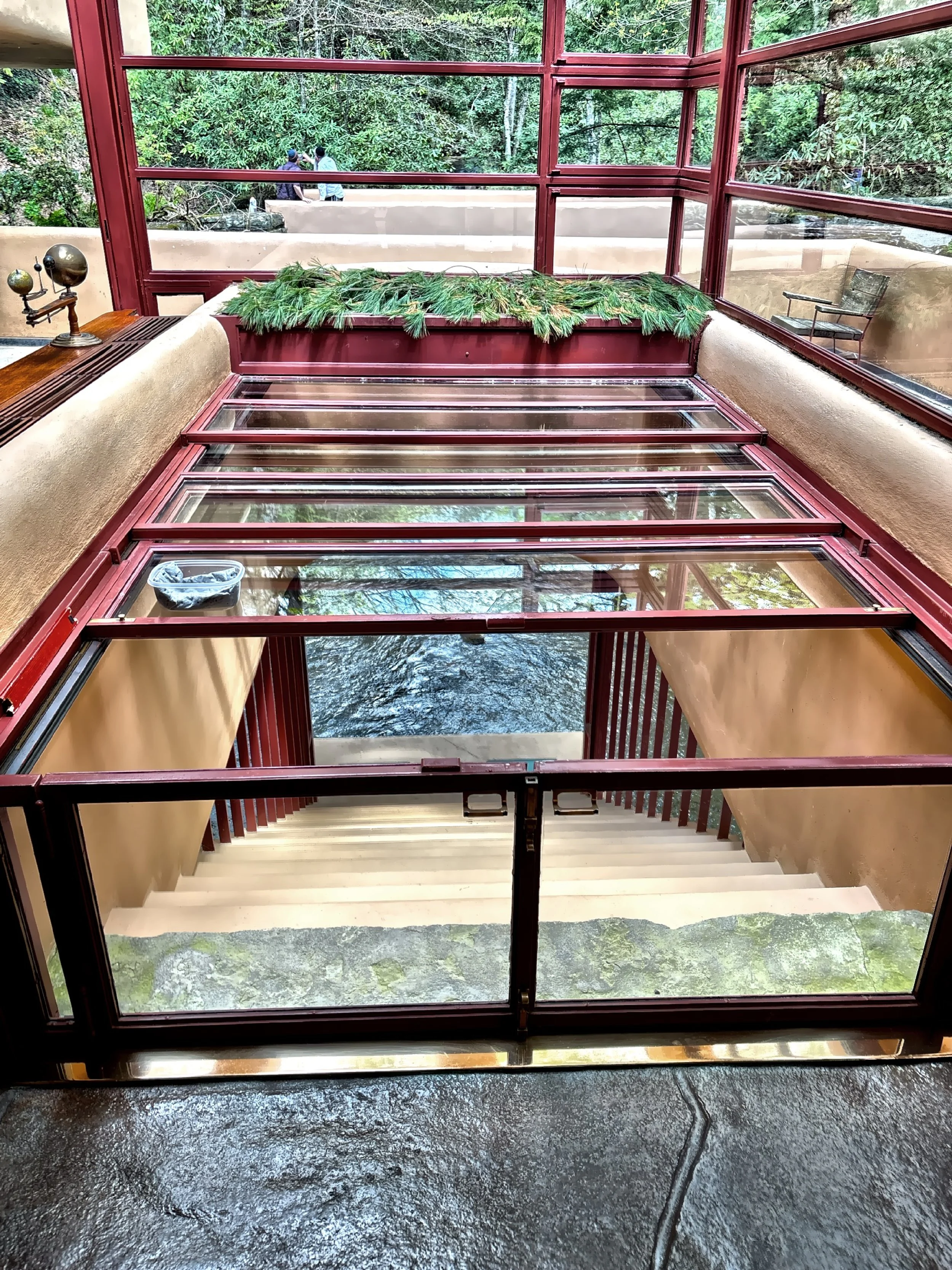  The glass enclosure and hatch in the living room that opens to a suspended stairway that descends to the stream below. 