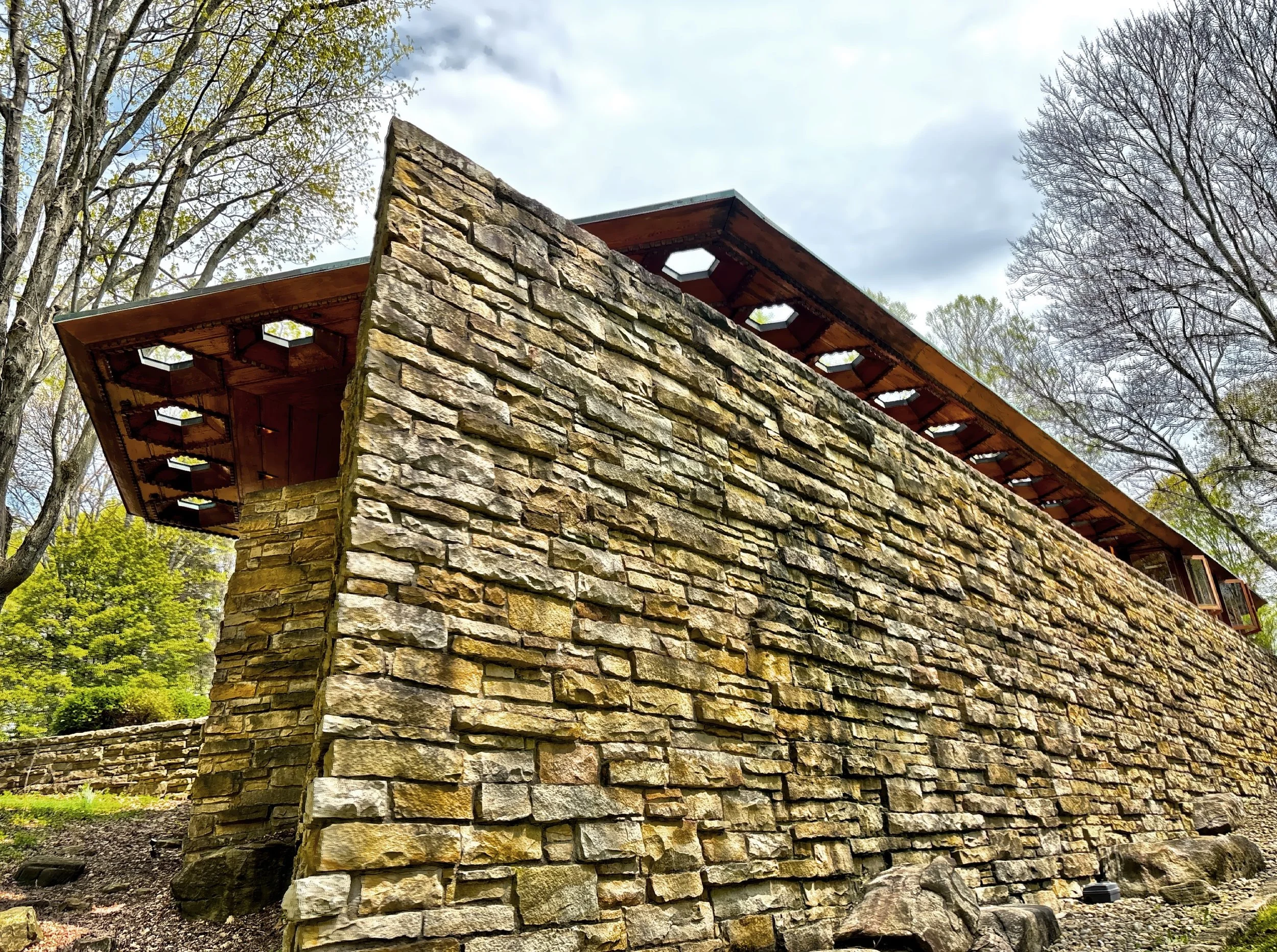  The view from the rear of the house with its sandstone walls and cantilevered roof over the wrap-around porch. 