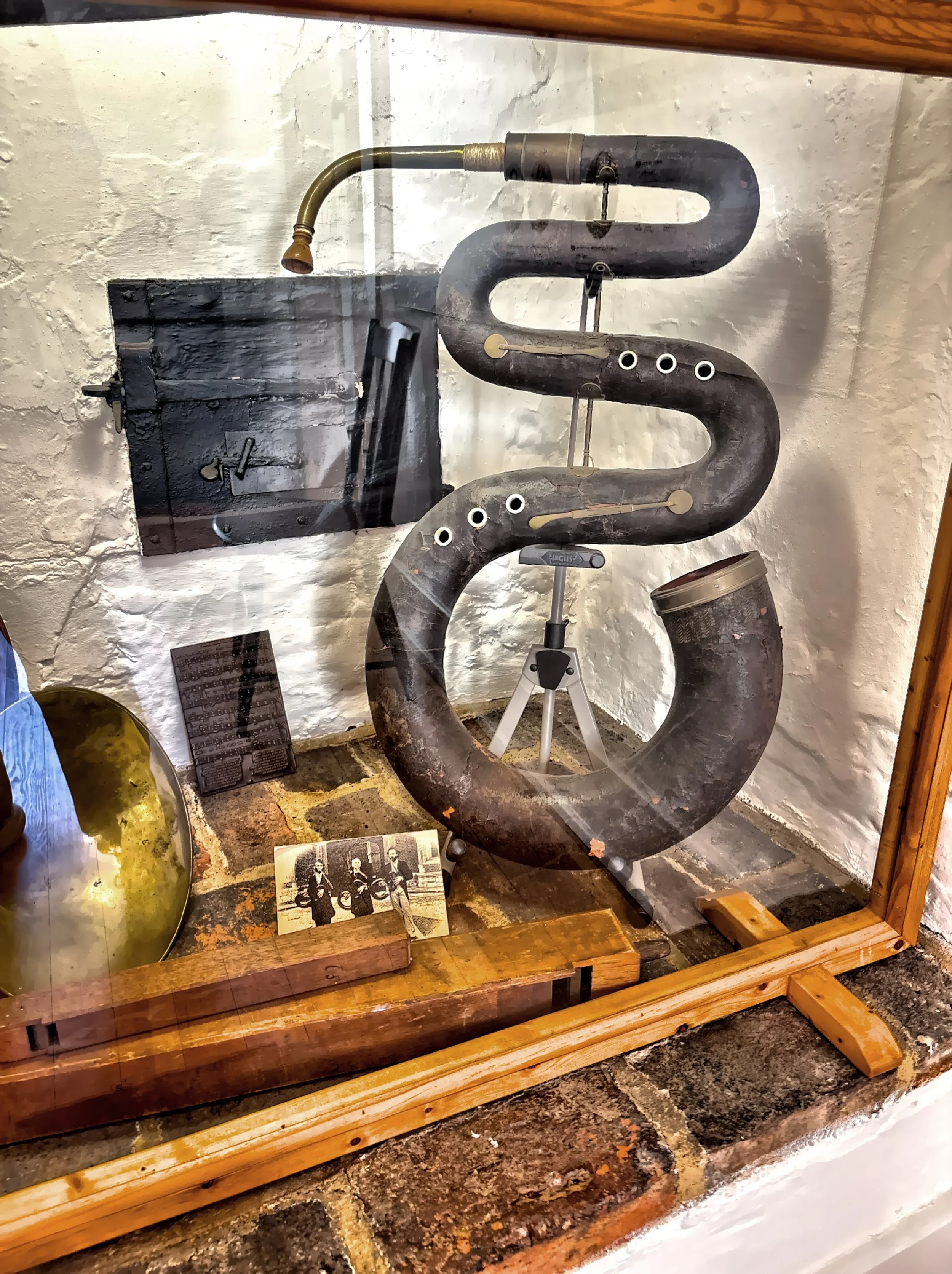  This instrument, called a Serpent, is made of wood and covered in leather.  It dates back to around 1800 and is considered to be part of the tuba family. 